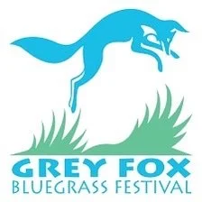 Blue-gray fox jumping over grass with text 'Grey Fox Bluegrass Festival'.