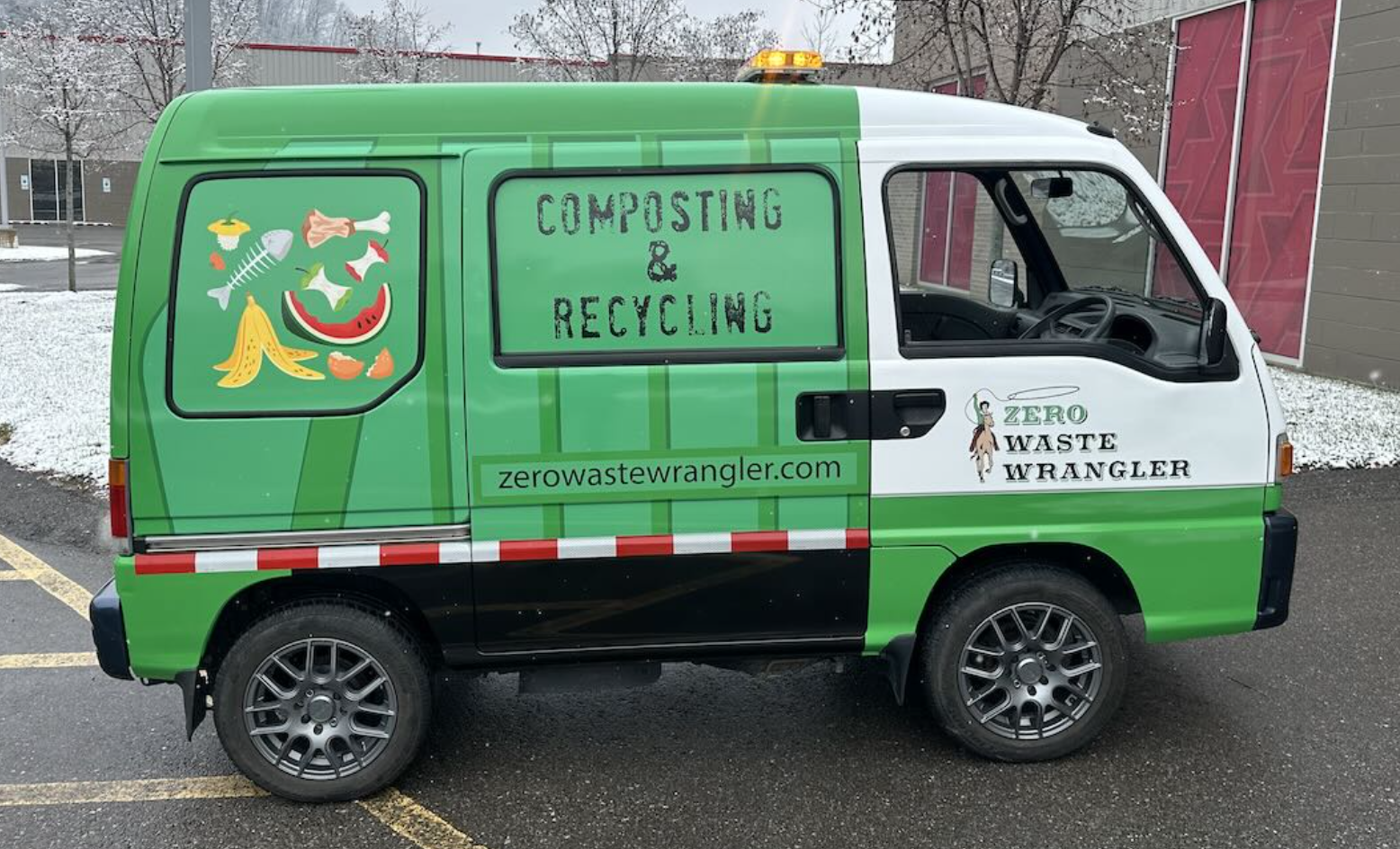 Small green and white van with signs promoting composting and recycling, featuring a watermelon slice, fish bones, banana peel, and text "COMPOSTING & RECYCLING" and "zerowastewrangler.com", parked outdoors during winter.