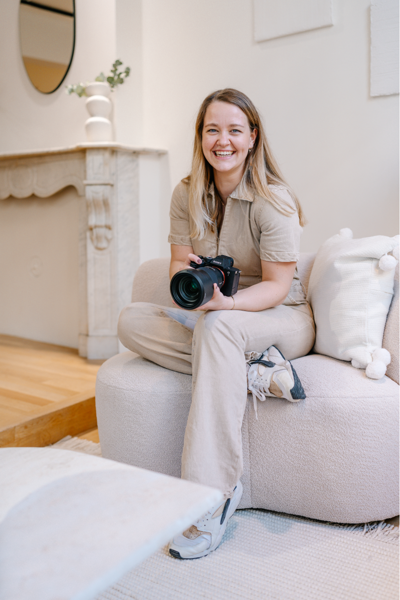 Megan van Meggie Ann Fotografie houdt haar camera beet en lacht naar de camera tijdens een personal branding shoot.