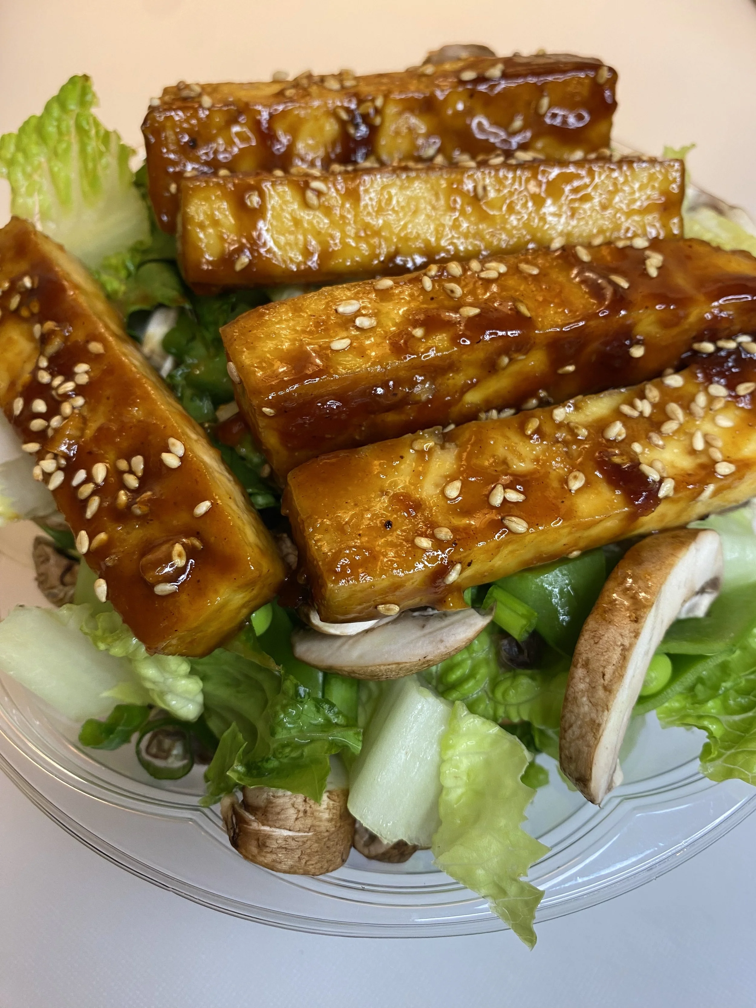 Sticky organic tofu, mushrooms, onion over romaine lettuce with side of a soy sauce dressing