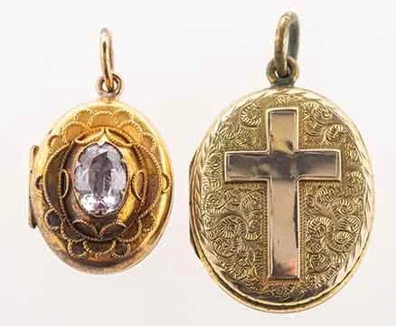 Two gold religious pendants, one with a large central gemstone and intricate filigree, the other with a cross and decorative engravings.