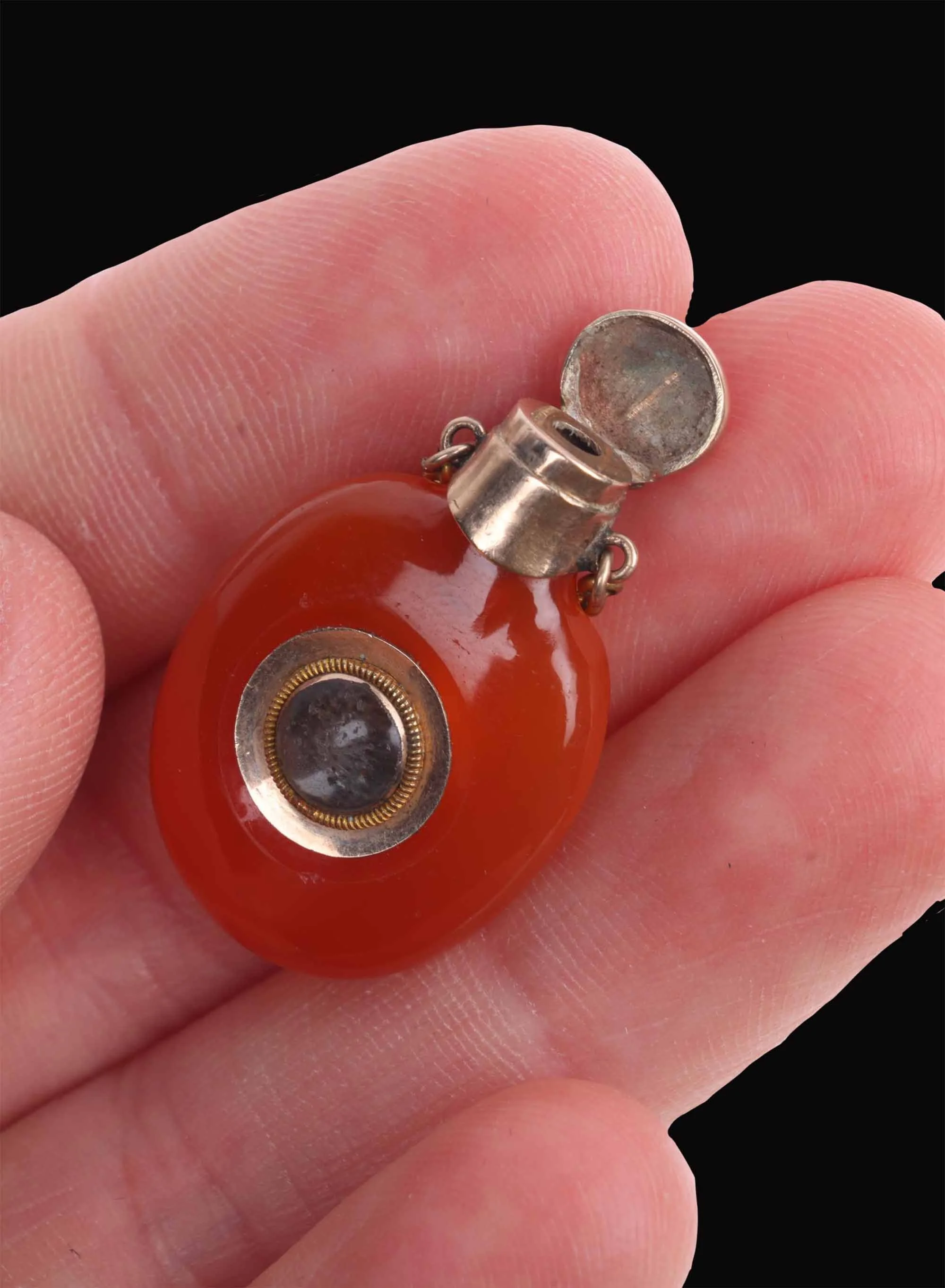 Georgian miniature mourning scent flask held in hand with hinged cap open.