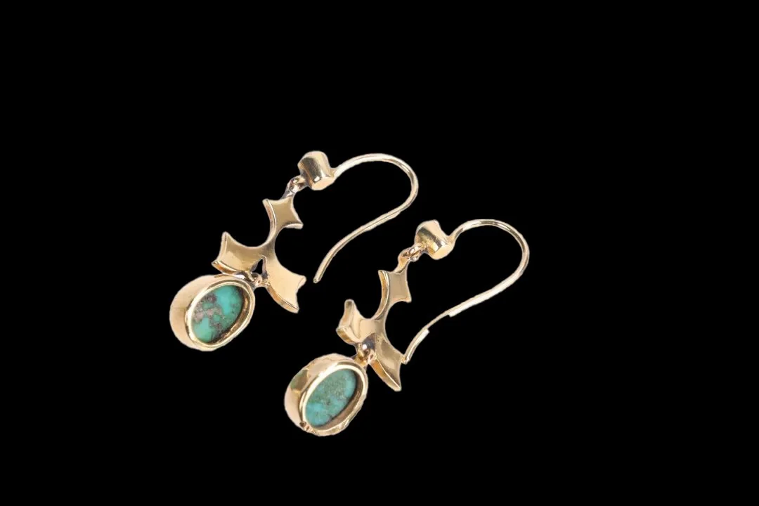 Reverse of antique gold turquoise and pearl earrings showing shepherd's hooks, openwork mounts and natural turquoise matrix on cabochon backs.