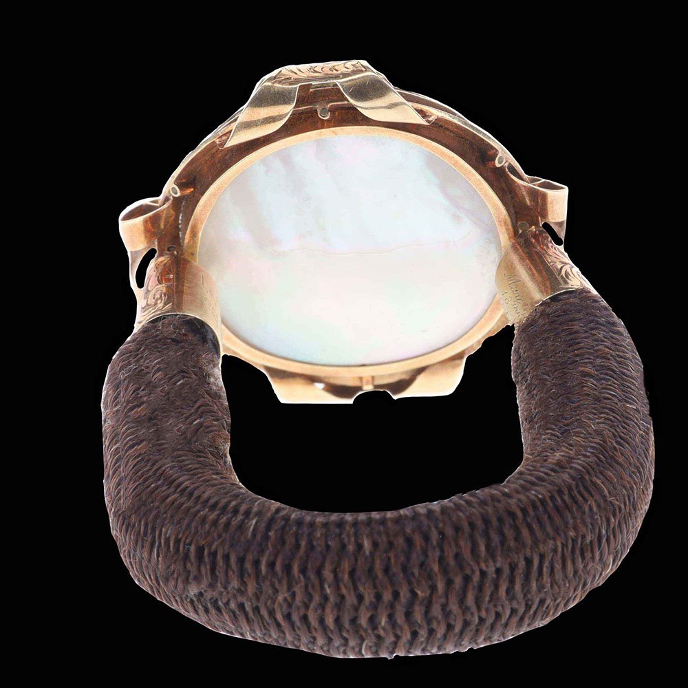 Reverse of Victorian hairwork bracelet showing mother-of-pearl locket backing