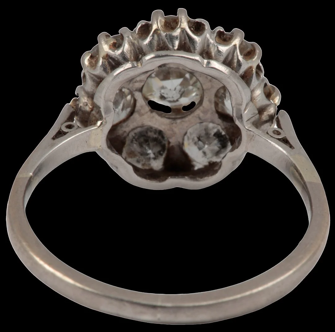 Underside of antique eight-stone diamond cluster ring showing open-backed settings, raised diamond gallery