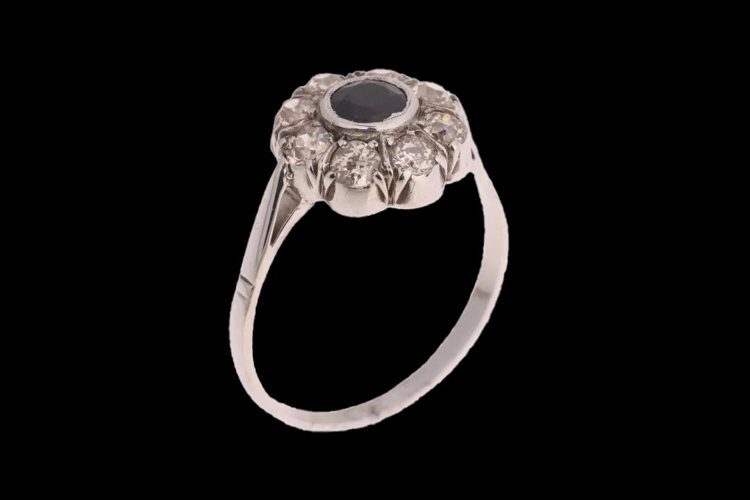 Side view of antique 18ct white gold sapphire and diamond cluster ring showing raised claw settings, rub-over sapphire bezel, and tapered band.
