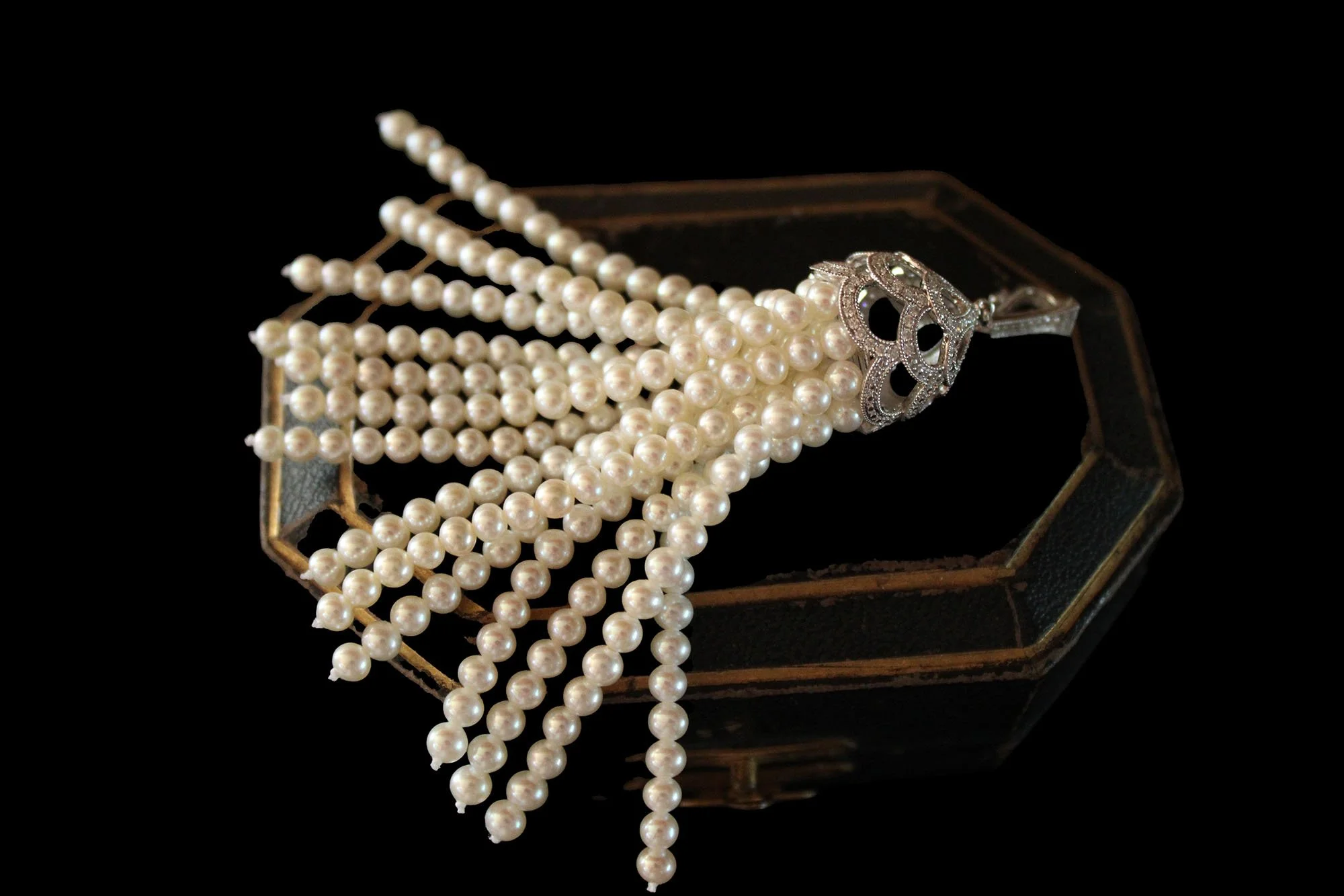 closed jewelry case with 18ct gold diamond and cultured pearl tassel pendant with pierced diamond-set cap