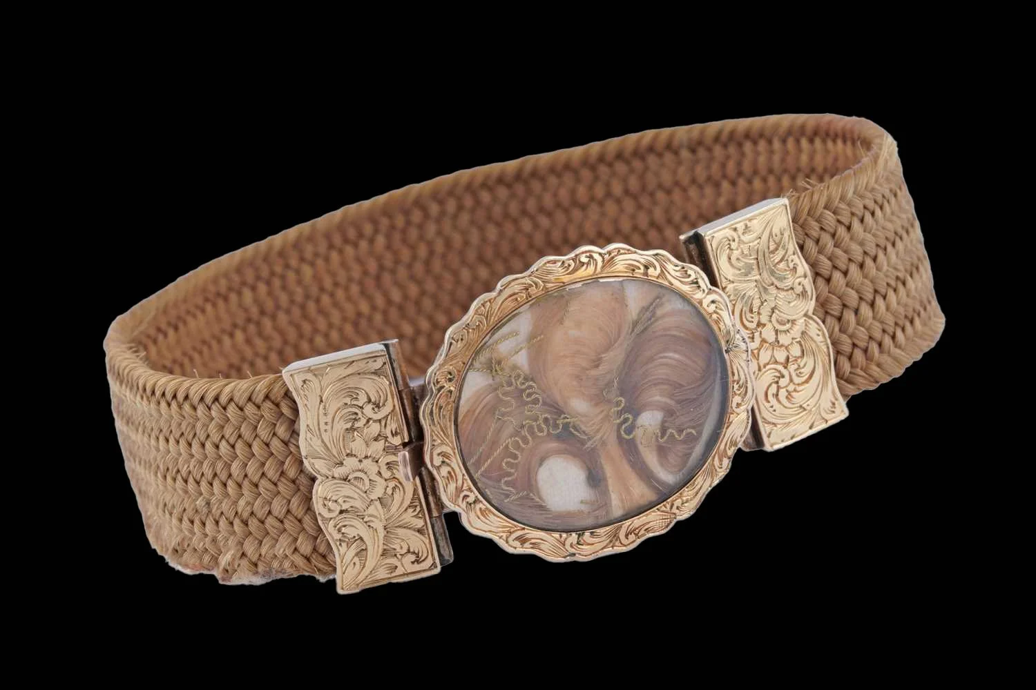 Victorian hairwork bracelet with braided hair band and glass locket clasp containing feather hairwork design with engraved 9K gold mounts