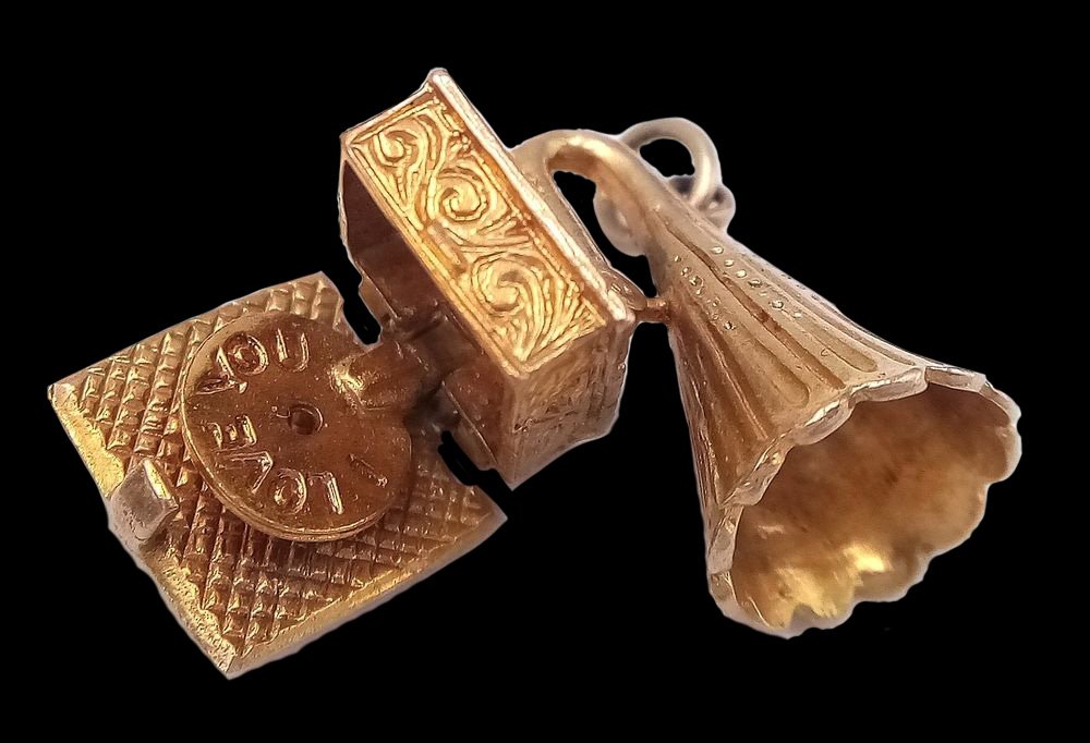Antique phonograph jewelry charm shown open and articulated