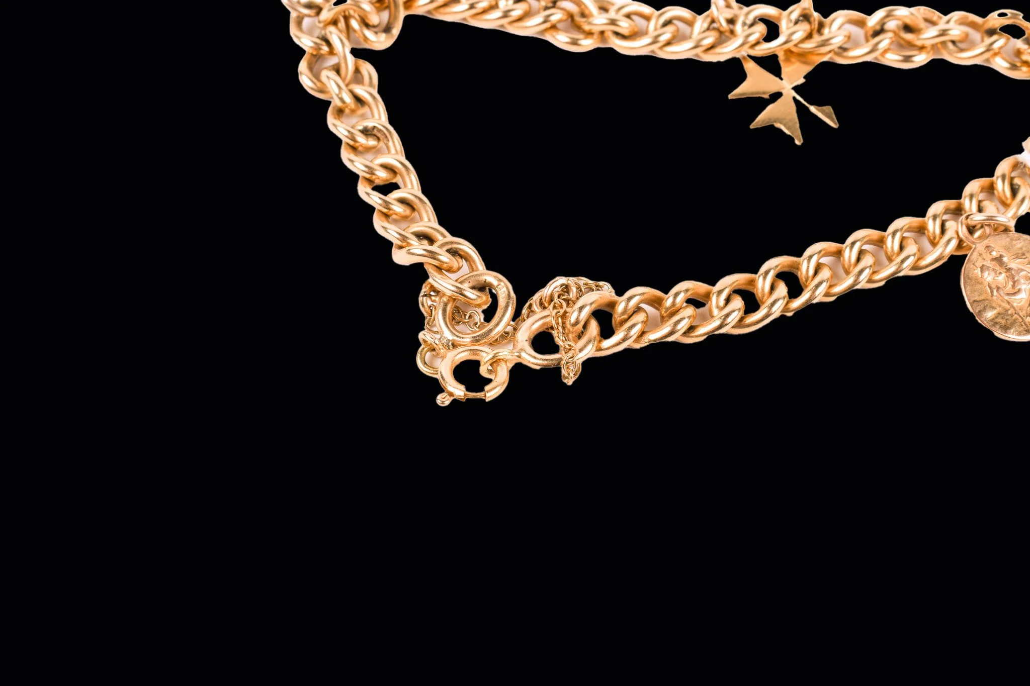 Detail of 9ct gold bracelet clasp with hallmarked links and attached security chain