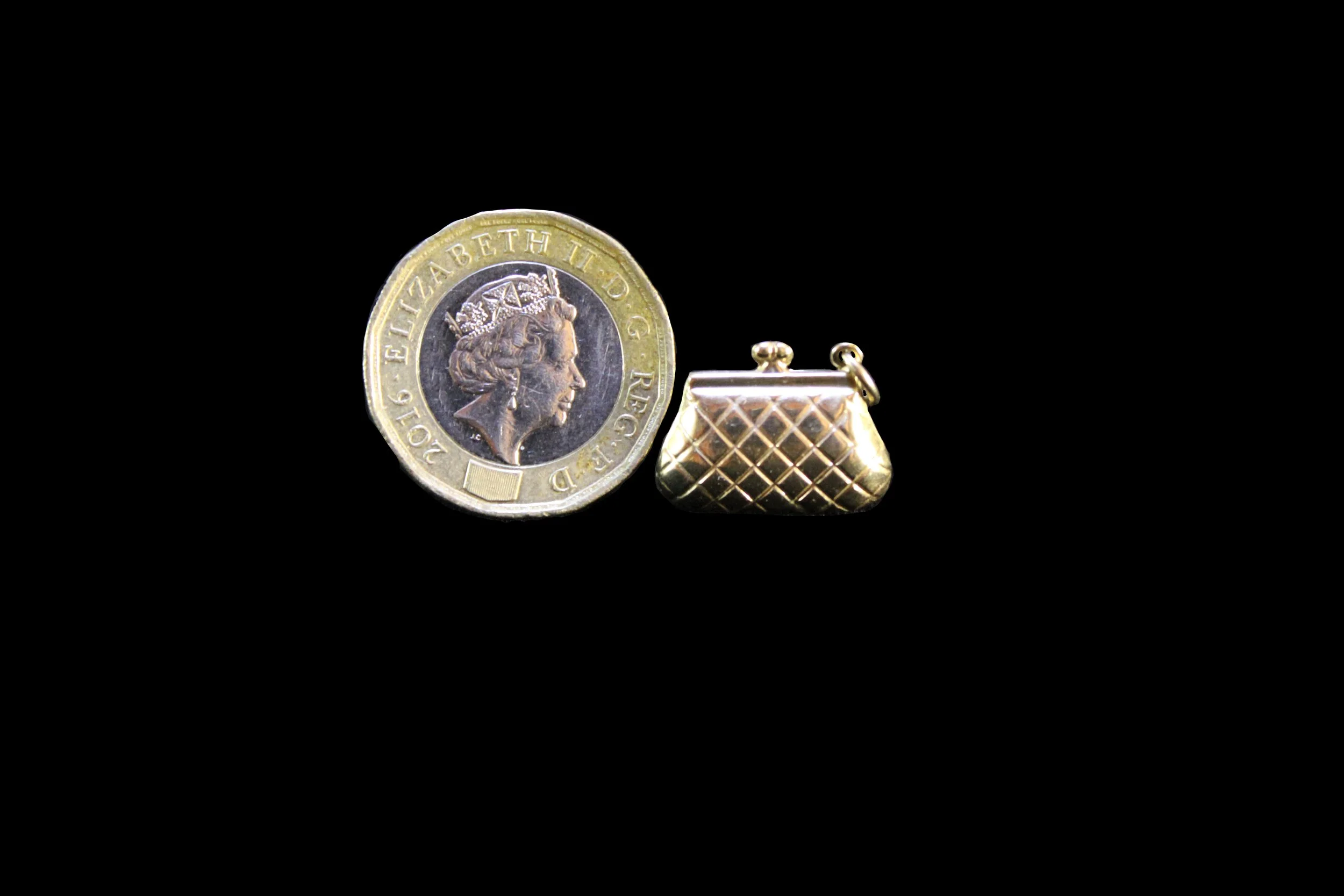 One Pound Coin shown with purse charm for scale