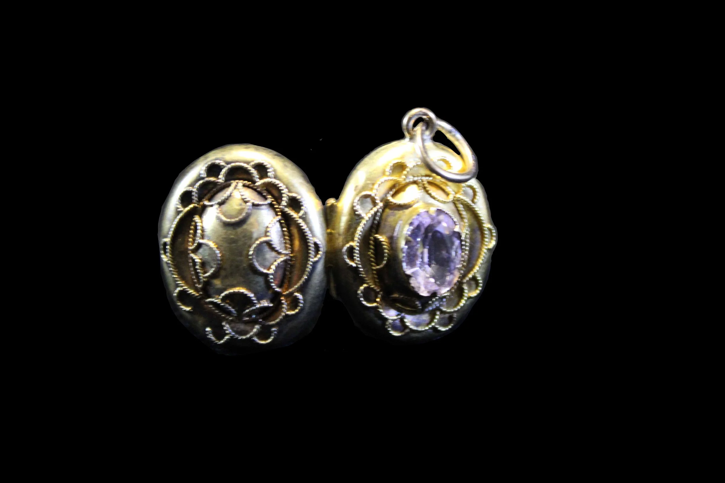 Victorian gold oval locket fully opened, showing gemstone front and decorative reverse panel