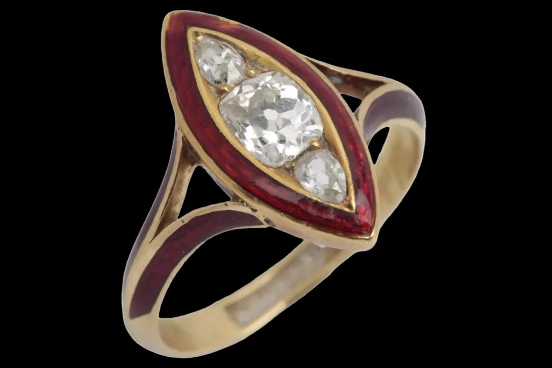 Victorian gold mourning ring with three antique-cut diamonds in a navette setting, bordered by deep red enamel extending onto split shoulders.