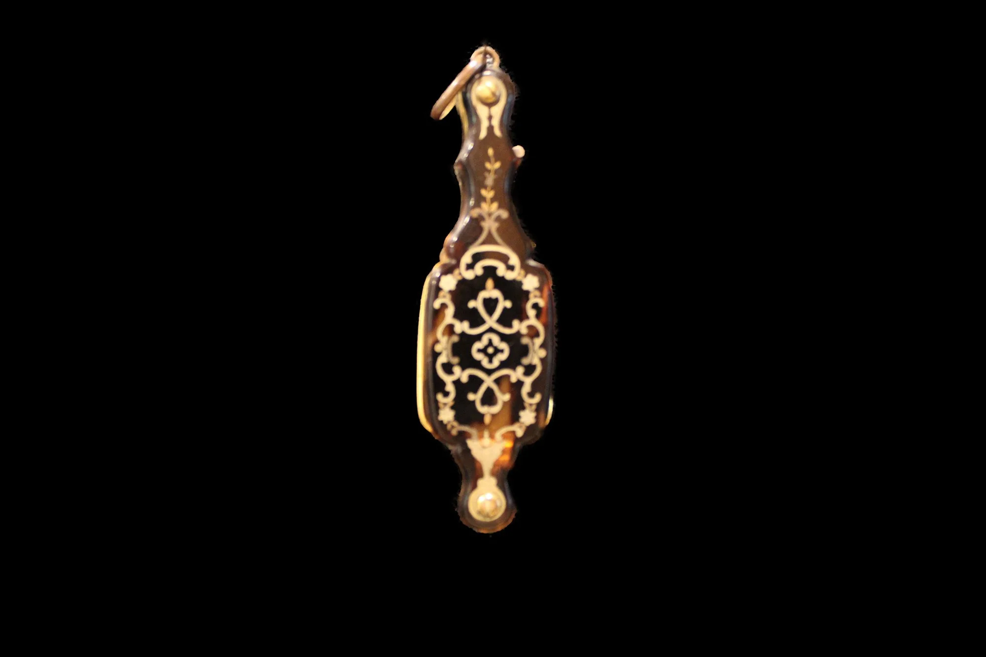 Closed, the lorgnette conceals its optical function behind a richly decorated tortoiseshell case.