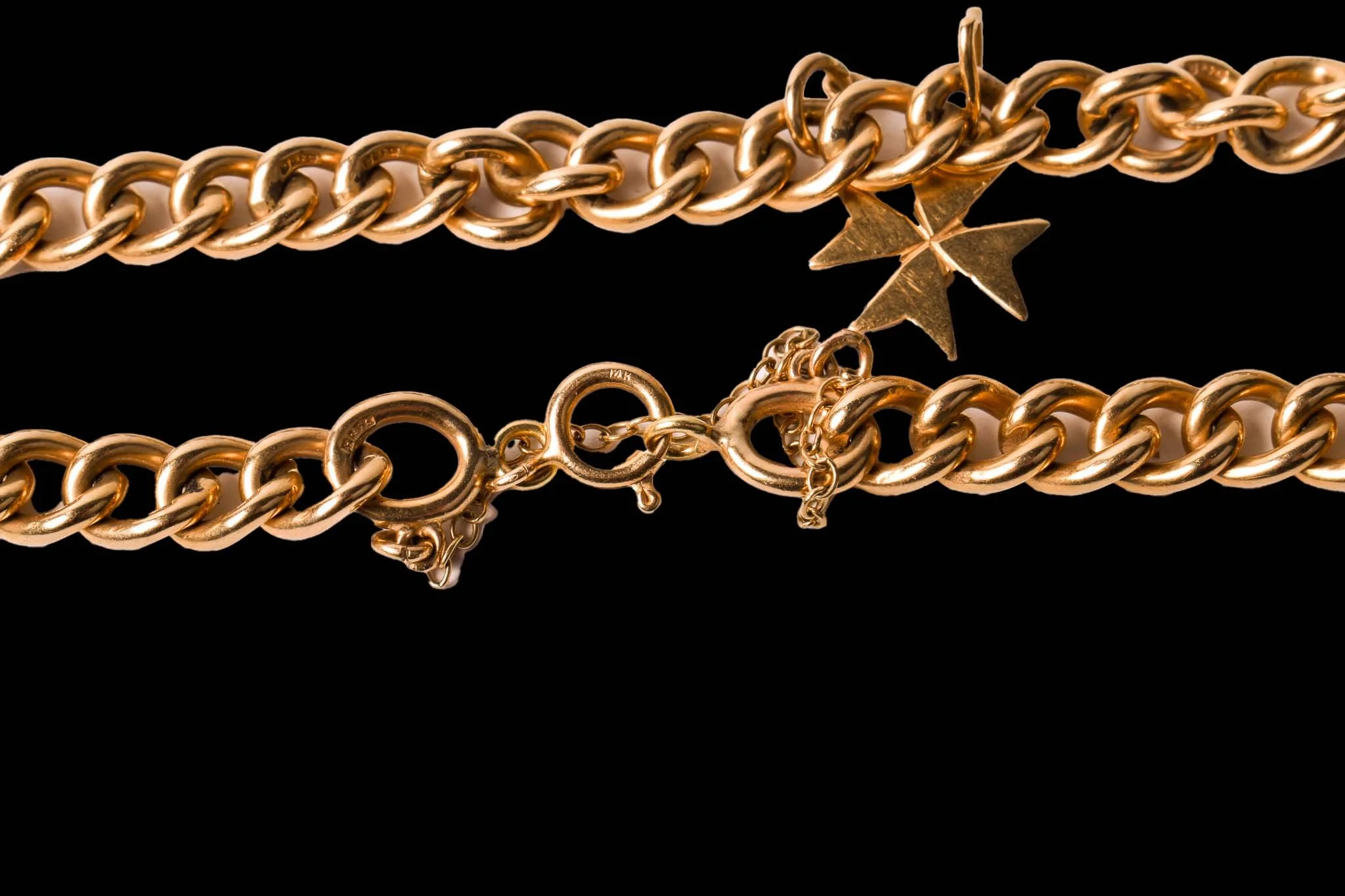 9K gold charm bracelet showing Maltese cross marked C.18 and heavy curb links.
