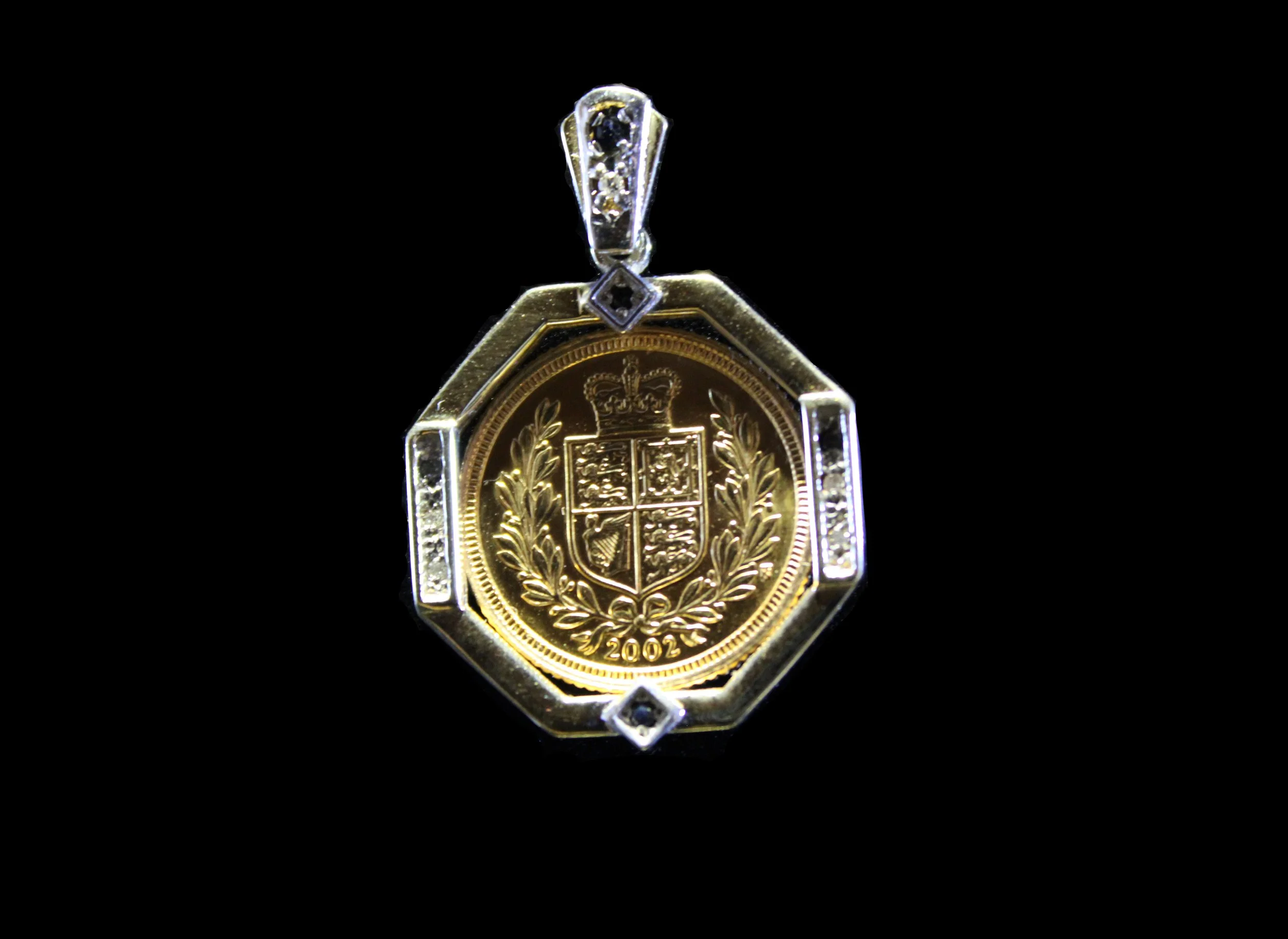 2002 British gold coin pendant showing crowned heraldic shield surrounded by laurel wreath in jeweled octagonal mount