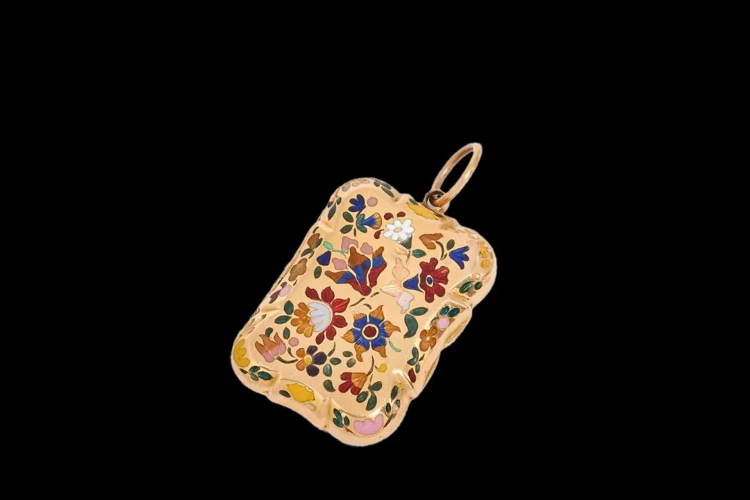 Angled view of antique Swiss gold vinaigrette with vivid blue, red, pink, green and yellow enamel flowers and gold suspension ring.