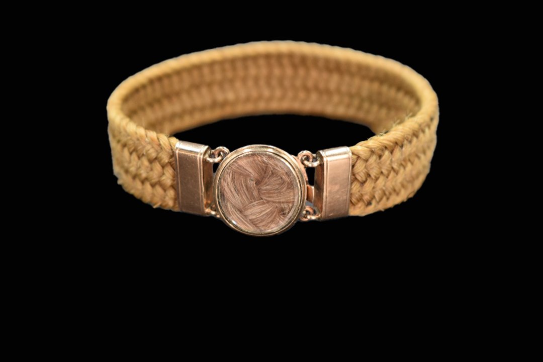 Victorian hairwork mourning bracelet with woven hair band and circular 9ct gold glazed locket clasp