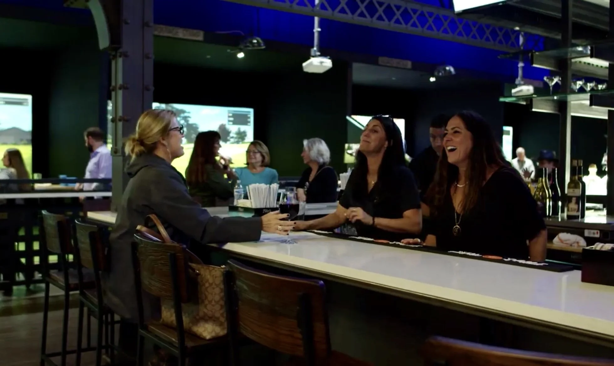 Friends laughing and enjoying drinks at the bar at Back 9 Social in Wallingford, CT