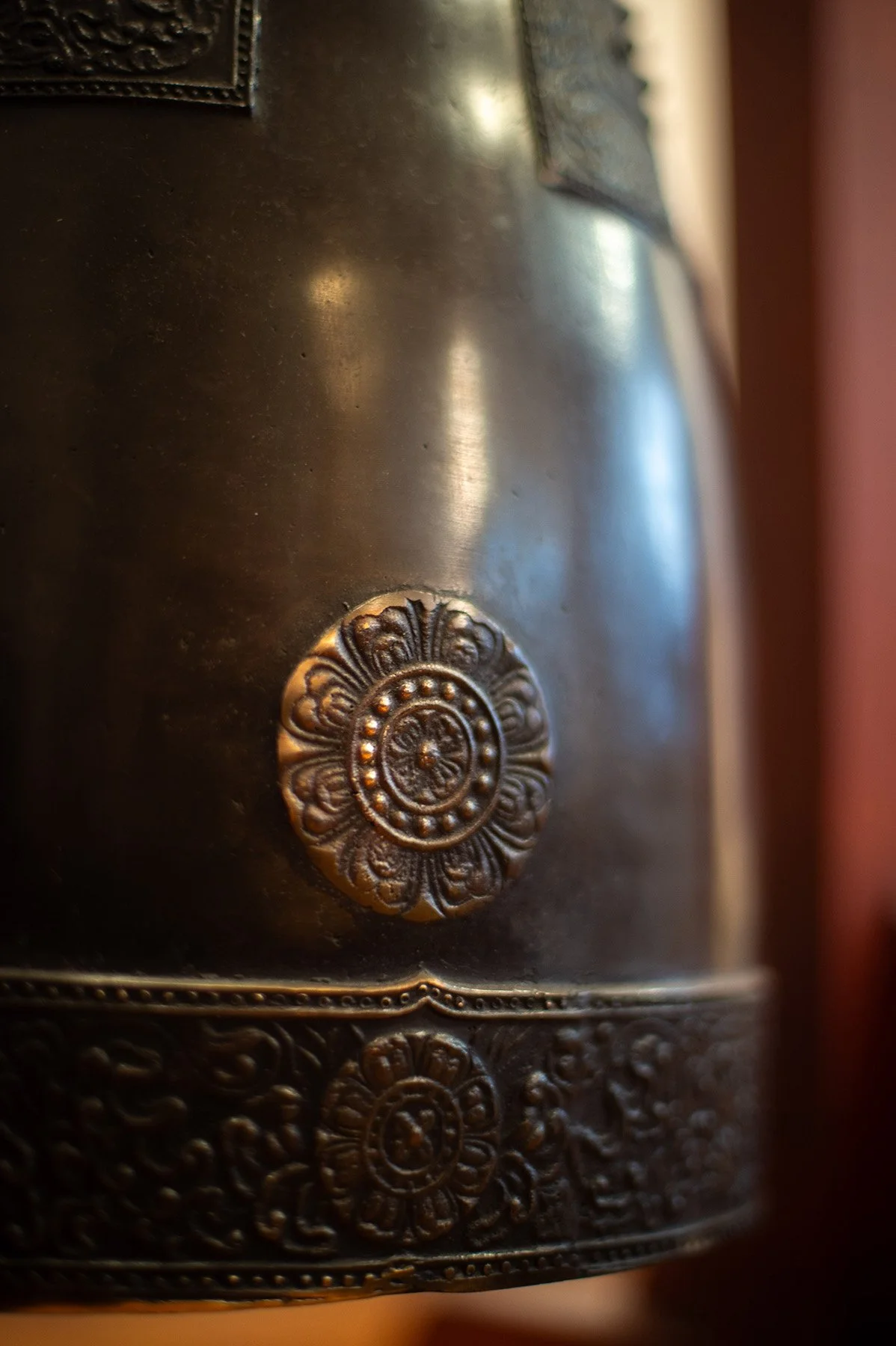 Close-up of the ceremonial bronze bell at Chogye International Zen Center of New York, 400 East 14th Street. Intricate lotus and floral relief carvings are visible on the bell's surface.