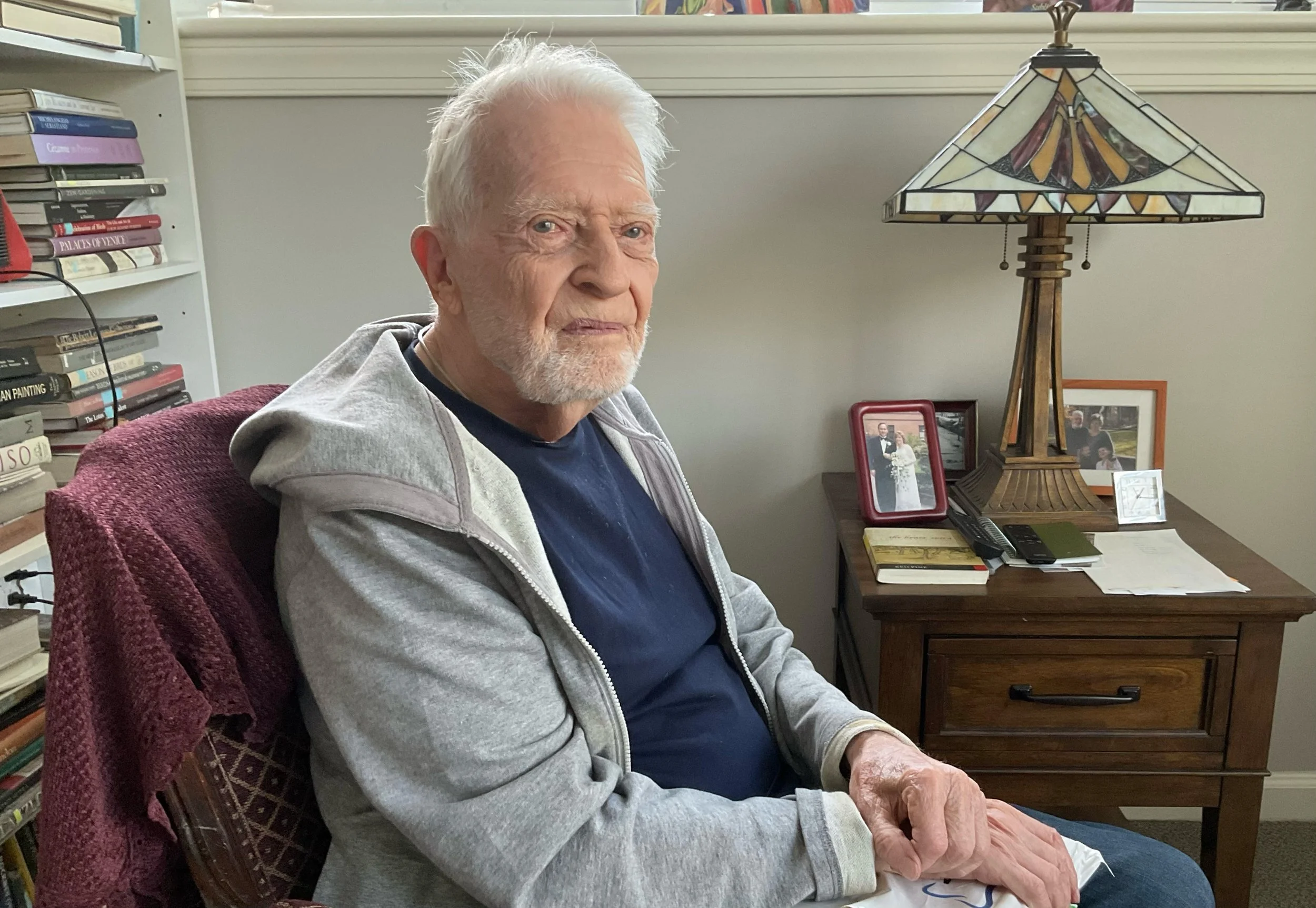 John Holland sitting in arm chair, 2026.