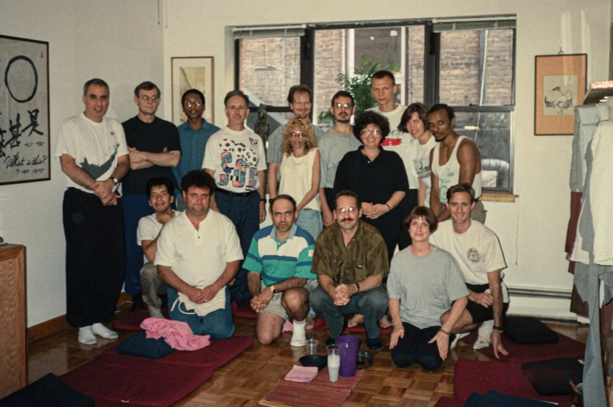 Group photo of Chogye International Zen Center practitioners in the dharma room at 400 East 14th Street, 1992. Members are dressed in casual clothing. Korean calligraphy and framed artwork are visible on the walls.