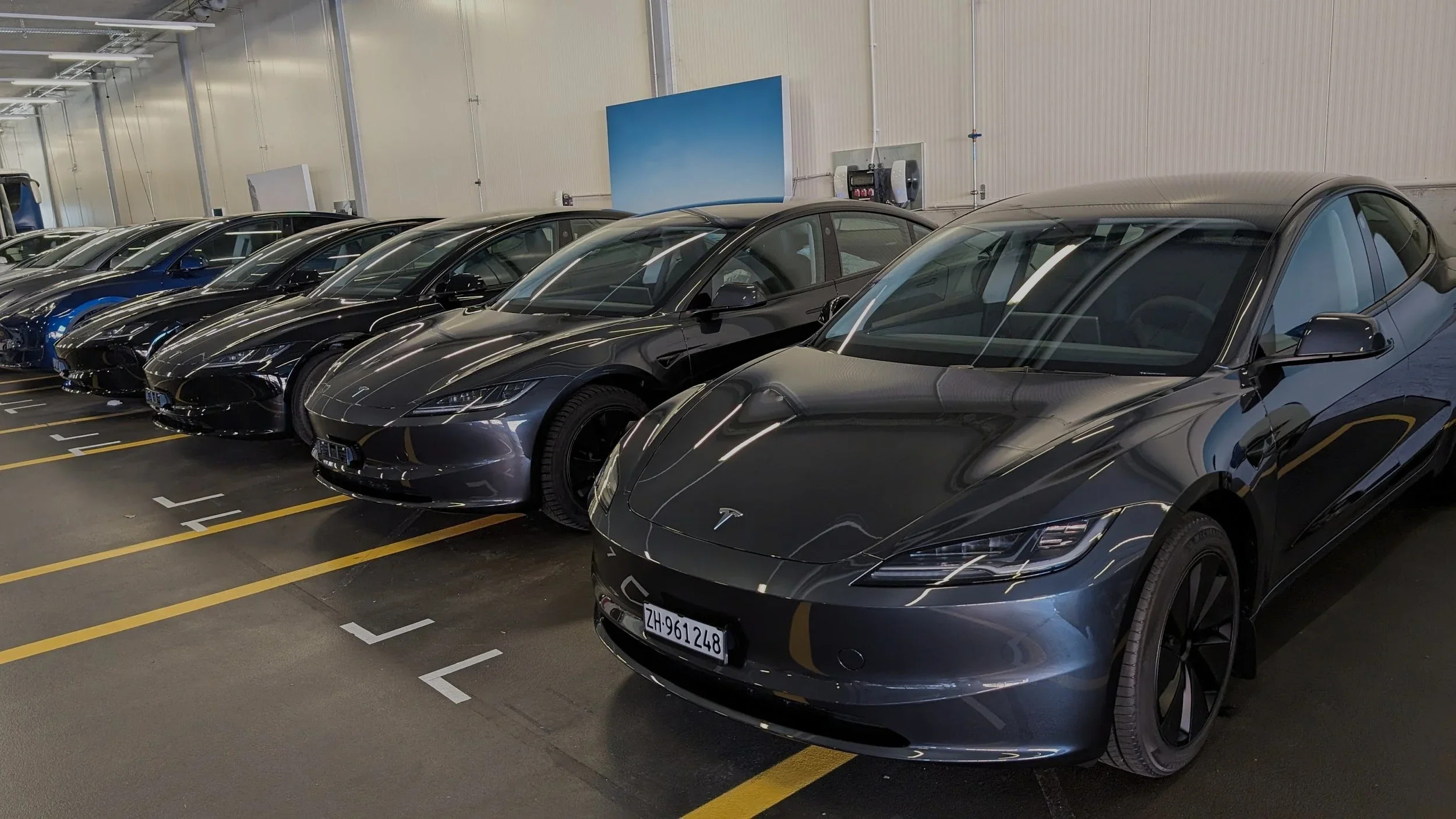 Several grey EV-Adventure Teslas parked side by side in a garage