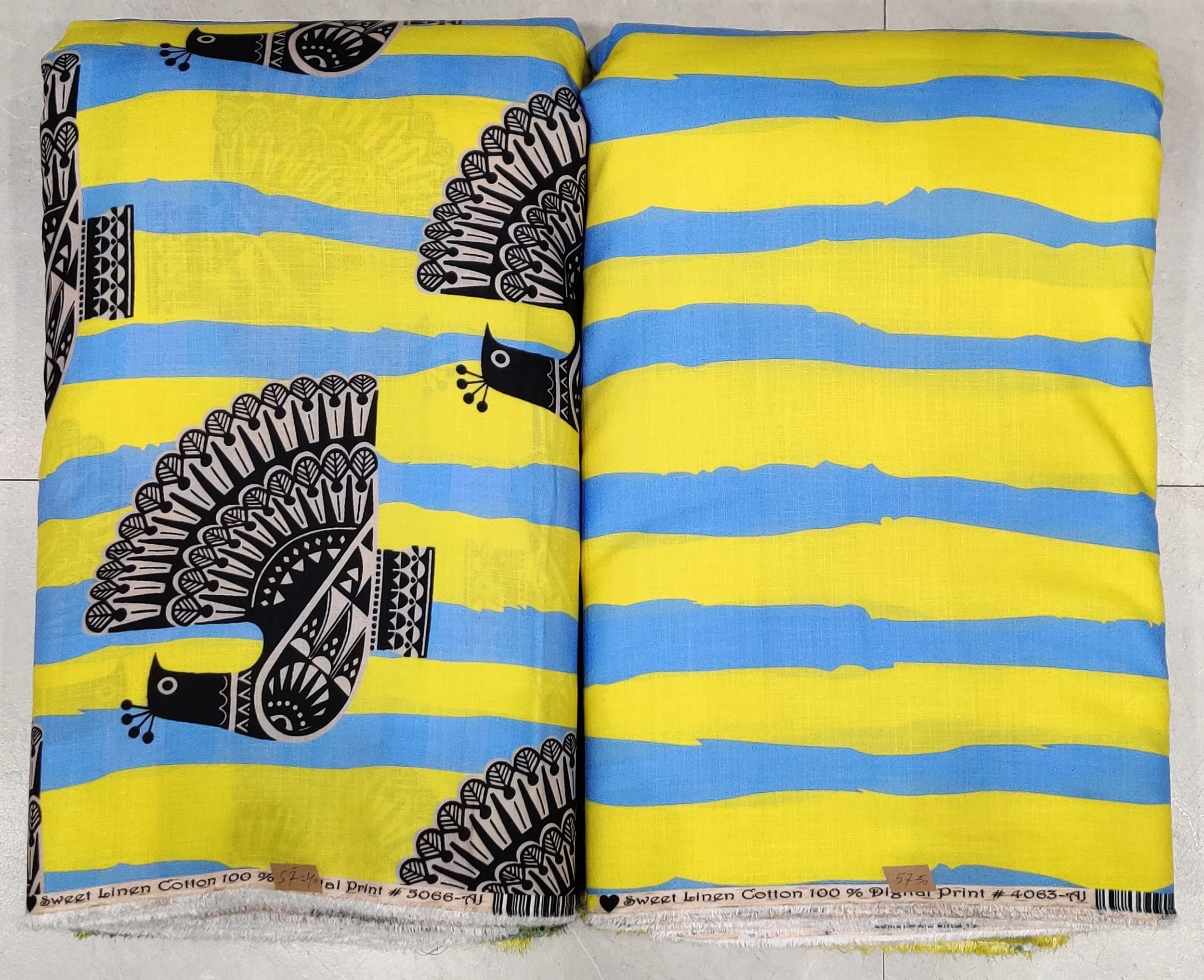 Vibrant turquoise-blue modal-cotton fabric featuring a bold stylized bird motif on the left panel, paired with a bright yellow-and-white horizontal striped right panel and an intricate geometric hemline border.
