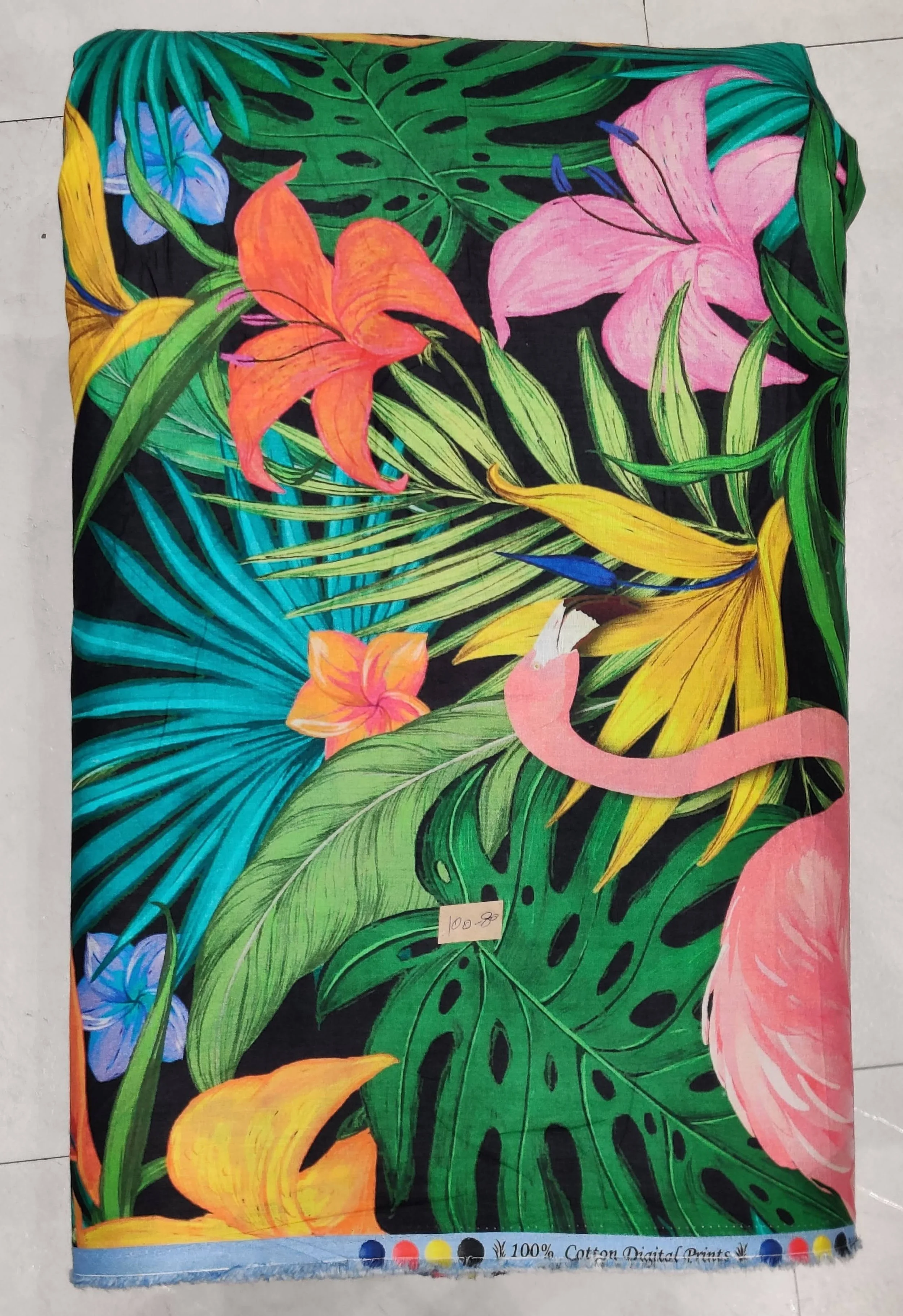 Rich royal blue background featuring a lush tropical jungle print with large monstera and palm leaves, accented by vibrant pink and orange exotic flowers and a graceful flamingo.