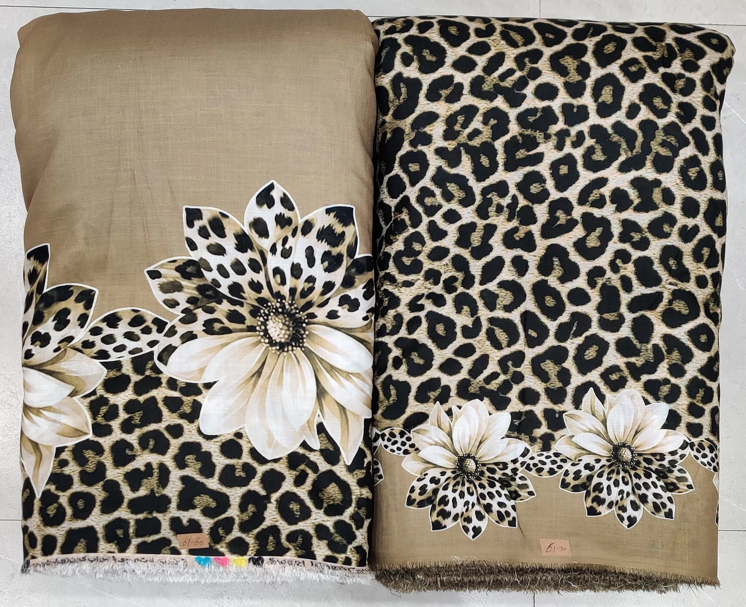 Luxurious beige and rich brown modal-satin fabric featuring a bold animal-print texture combined with large, elegant cream floral motifs, designed for statement ethnic wear and sophisticated draped garments.