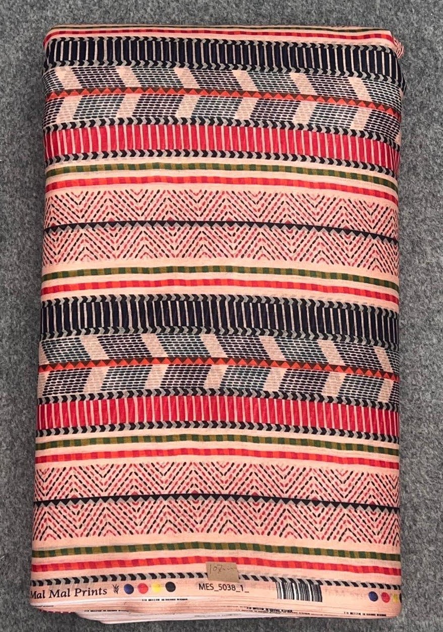 A folded fabric with horizontal stripes and geometric patterns in colors including black, red, pink, green, and beige, placed on a gray textured surface.