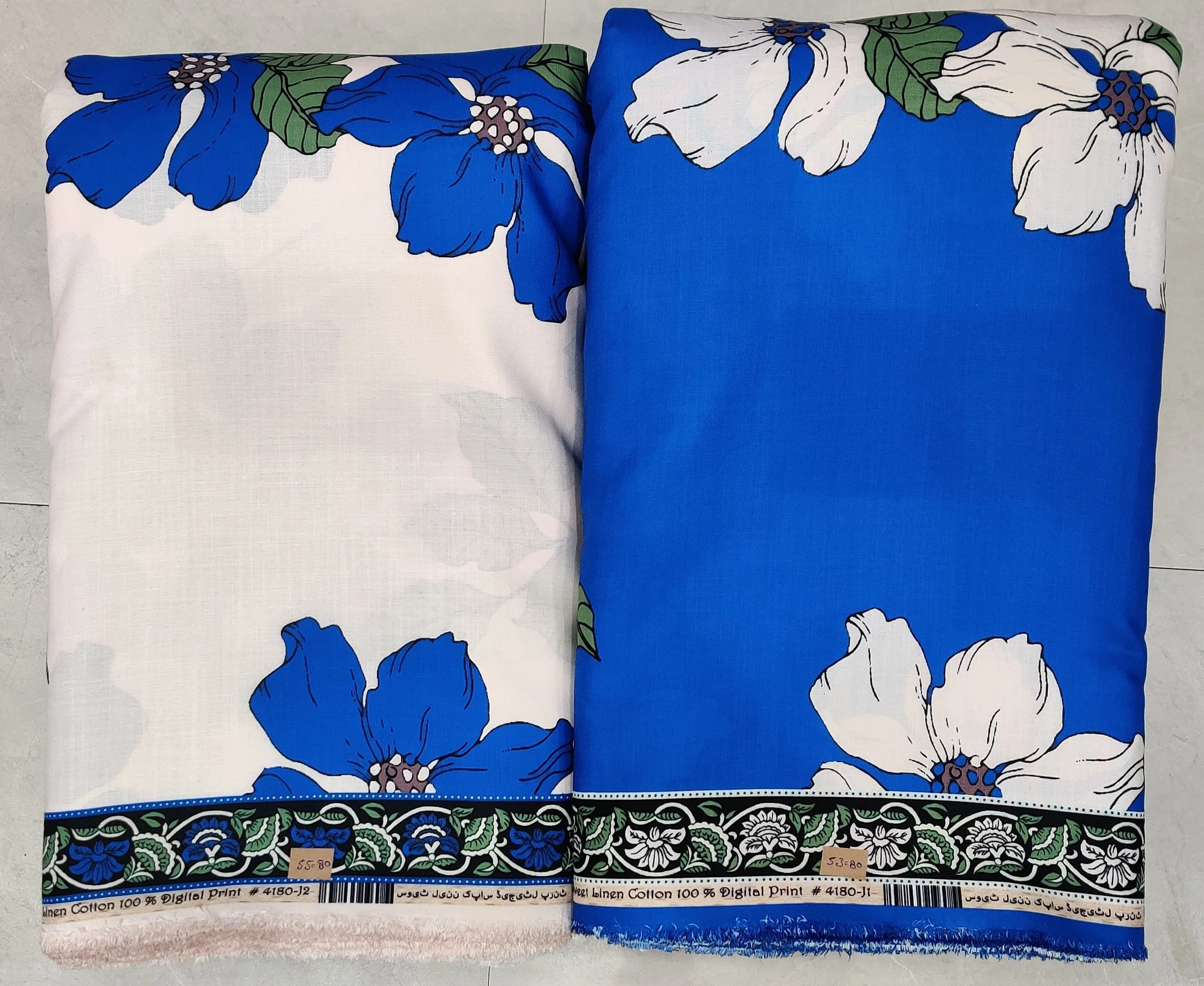 Crisp white and bold royal-blue fabric featuring a striking abstract botanical motif, paired with a solid vibrant blue side panel and an intricate ornamental border hem.