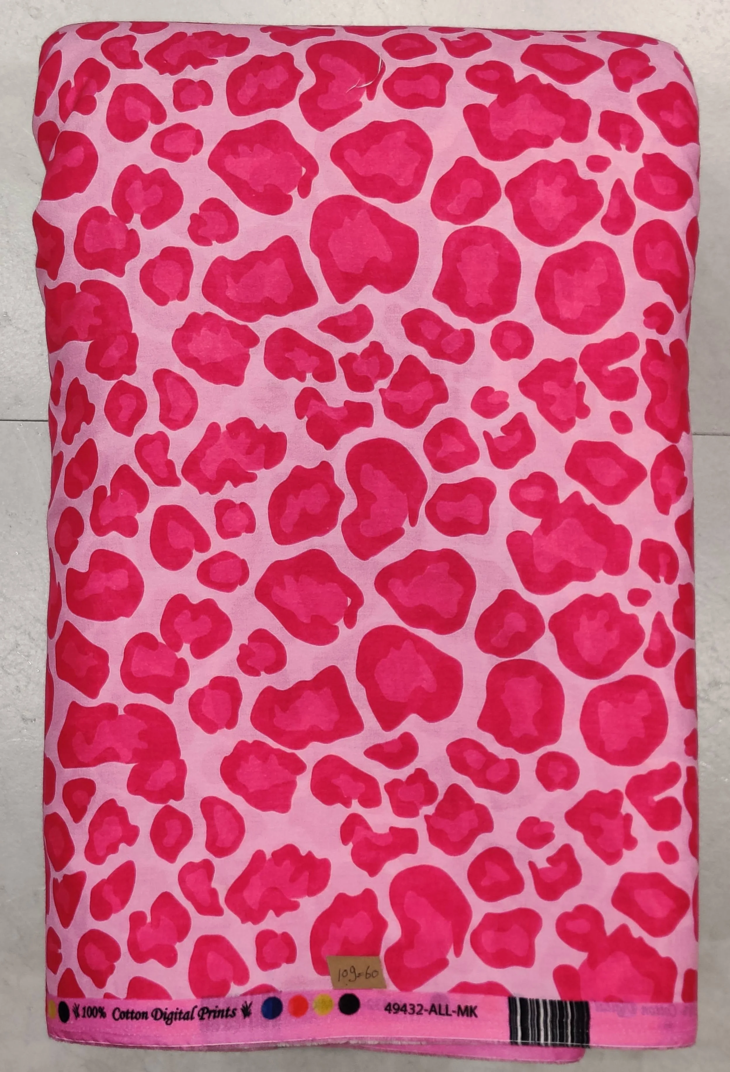 Vibrant hot pink printed fabric featuring a bold, repeating dark red stylized leopard spot pattern.