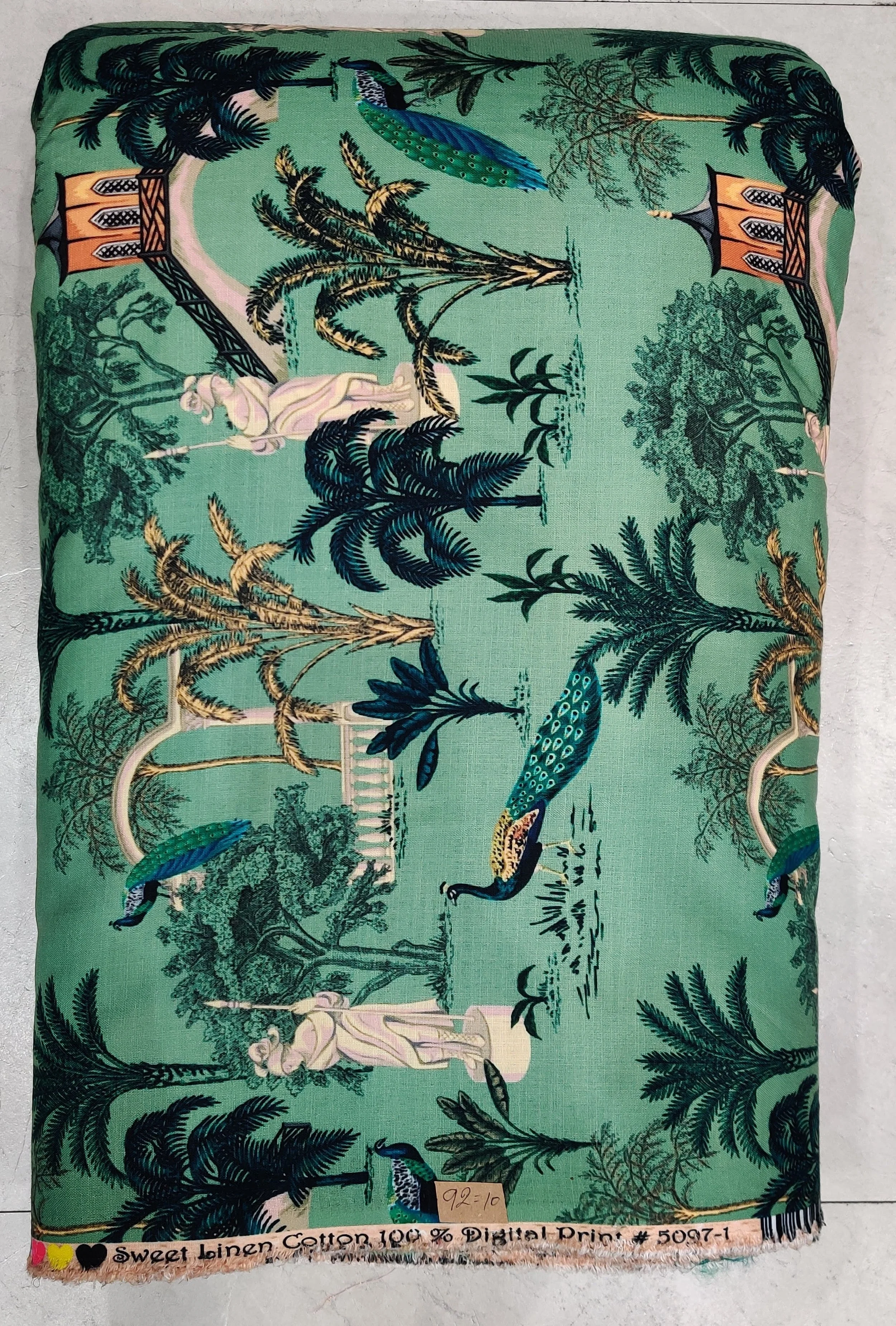 Rich mint-green and deep charcoal fabric featuring a lush tropical landscape print with slender palm trees, exotic wildlife motifs, and dense jungle foliage.
