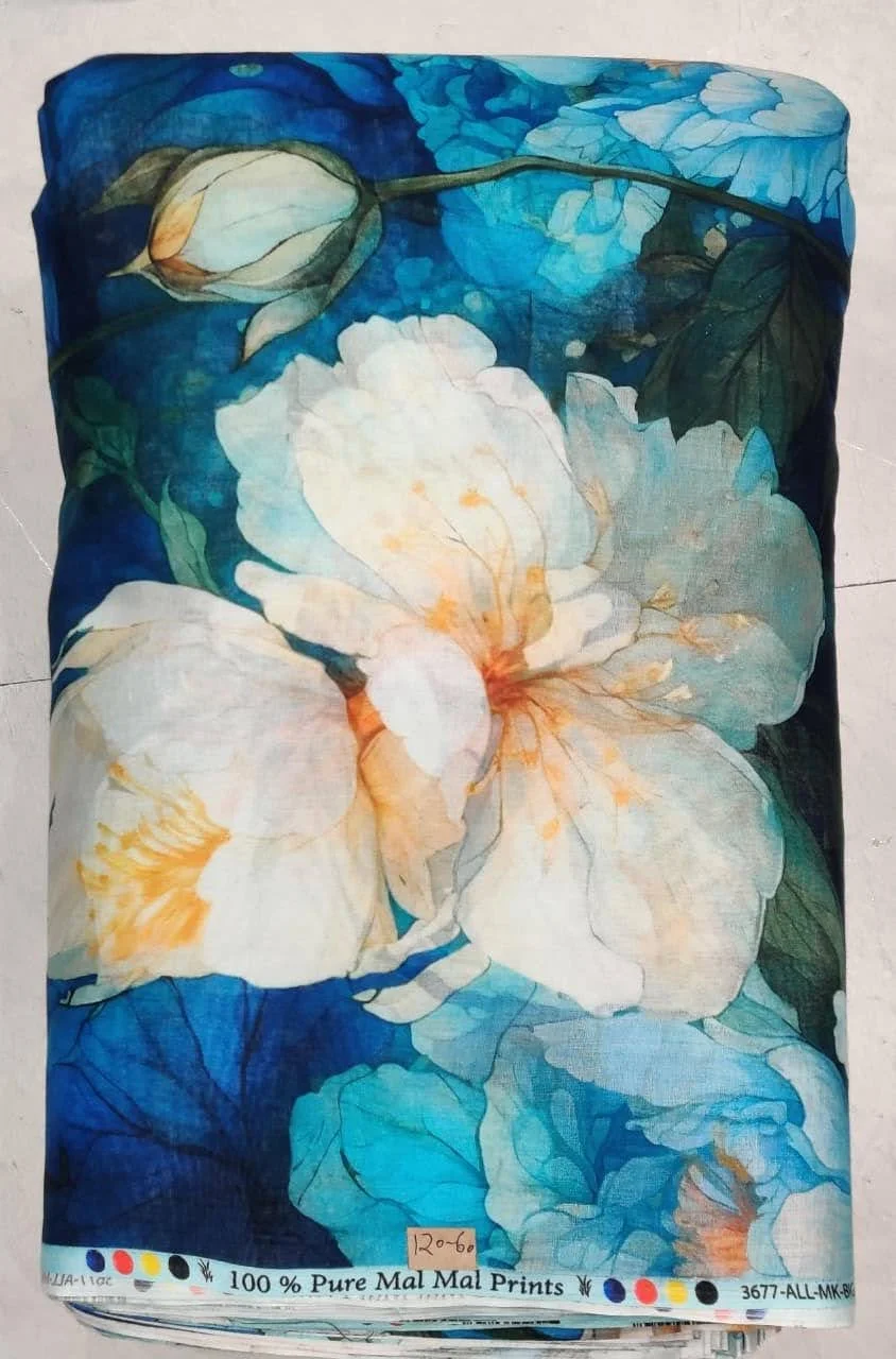 A fabric with a floral design featuring large white and peach-colored flowers with blue and green leaves, set against a vibrant blue background.