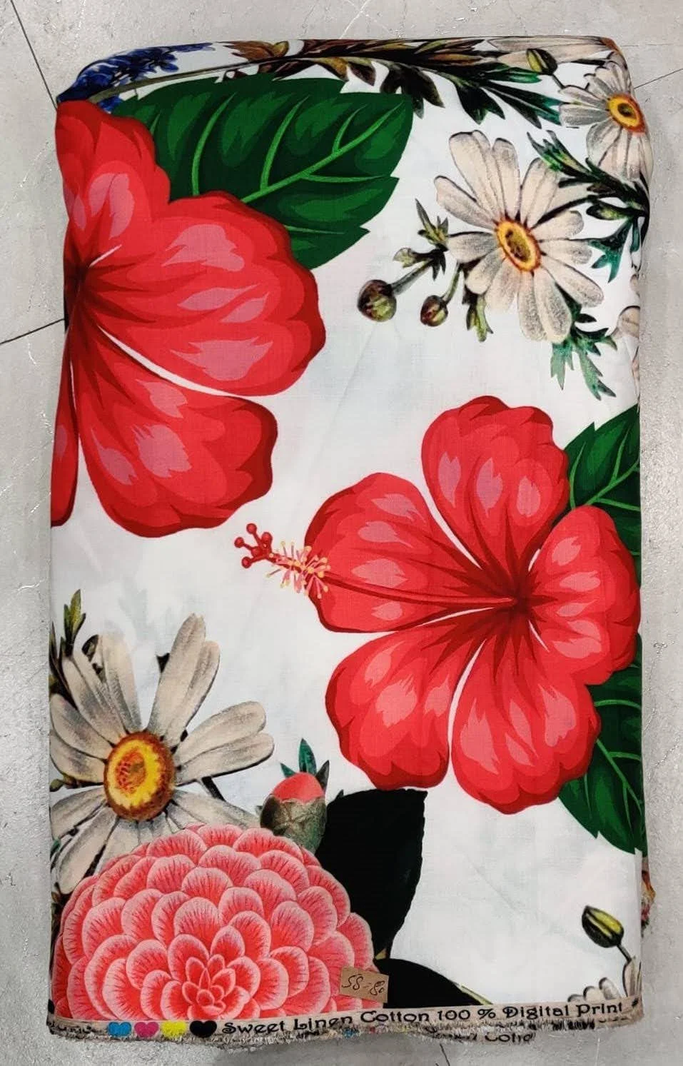 Pristine white and cherry-red tropical fabric featuring large-scale blooming hibiscus flowers and delicate white-and-yellow wildflowers, perfect for resort-wear dresses and breezy summer silhouettes.