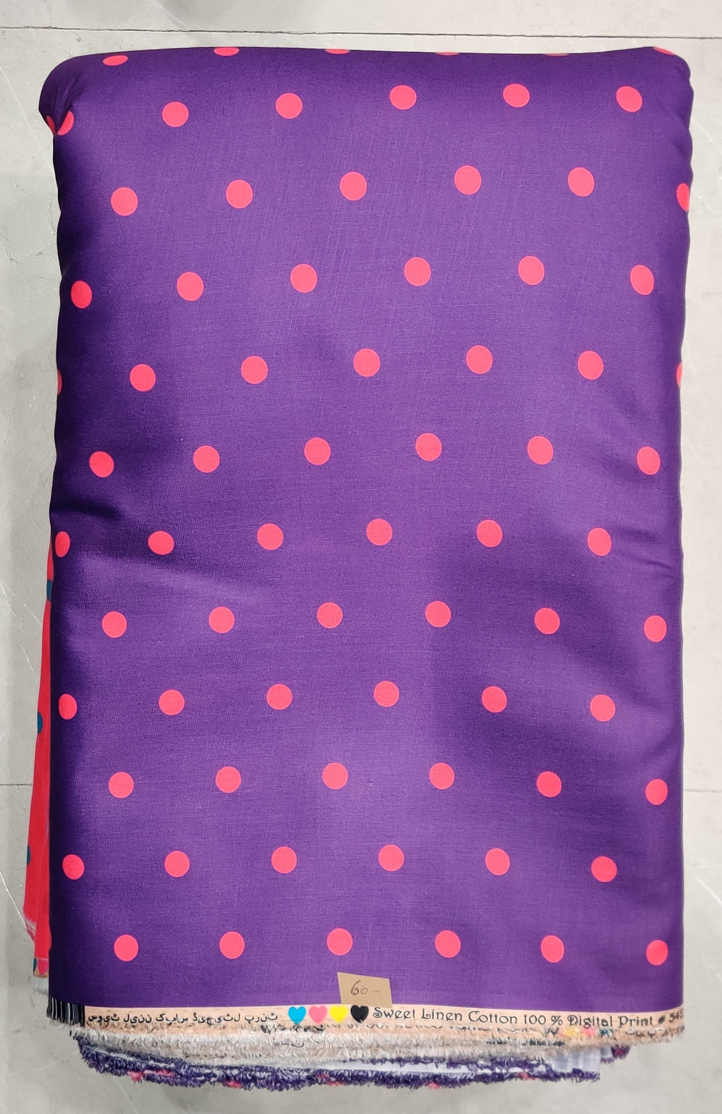 Vibrant royal-purple modal-cotton fabric featuring an all-over tiny neon-coral polka-dot print, detailed with a delicate multi-colored woven border hem.