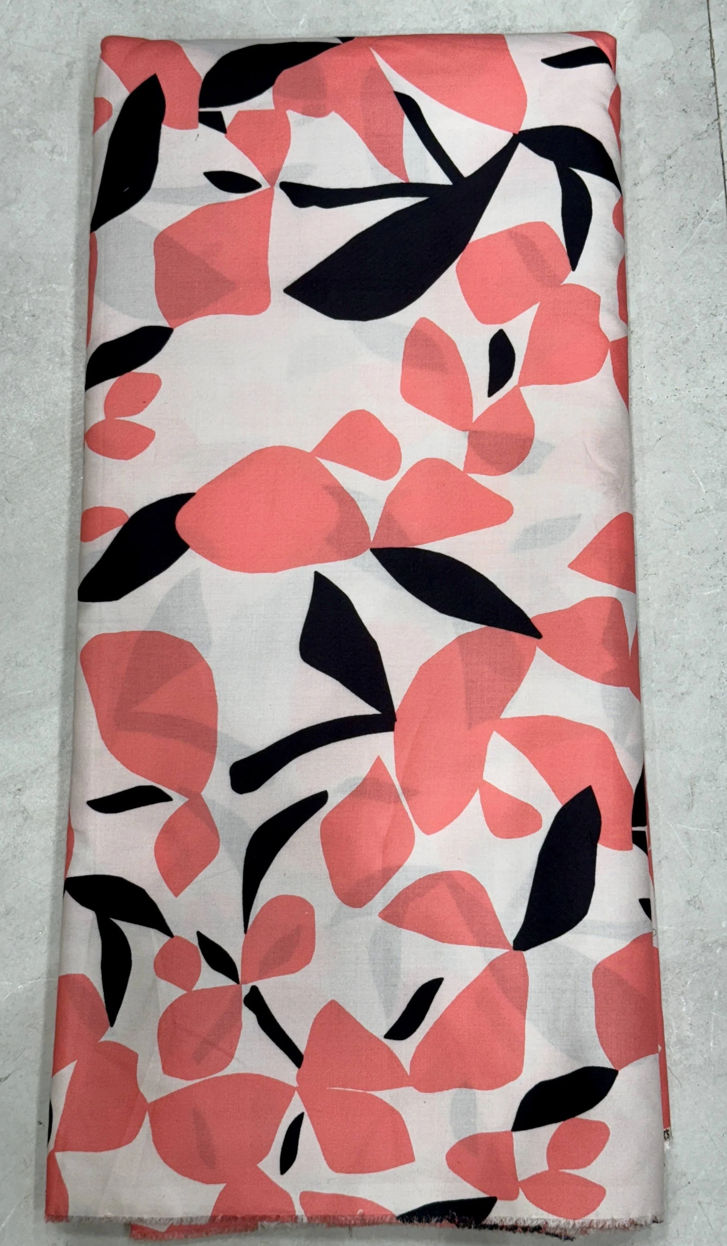 Crisp white fabric featuring an abstract botanical print with bold, flowing coral-pink leaves and sleek black organic shapes.