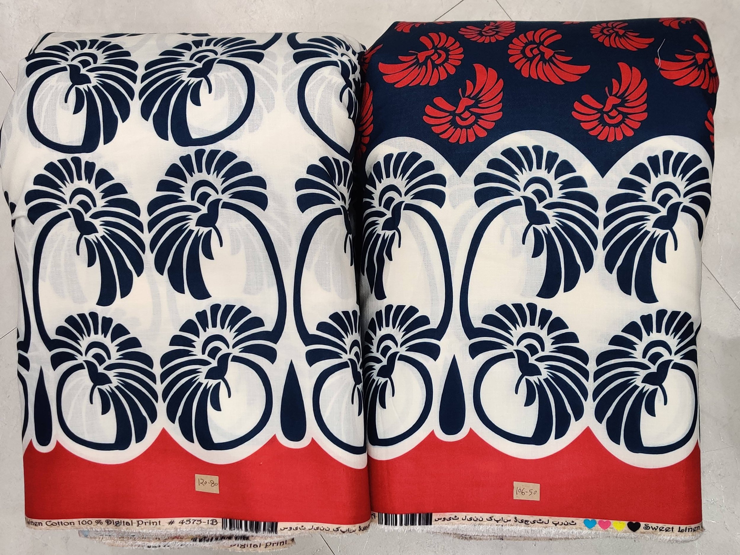 Classic indigo-blue and pristine white fabric featuring a bold central medallion motif, paired with a repeating geometric border and a vibrant red-and-white hemline accent.