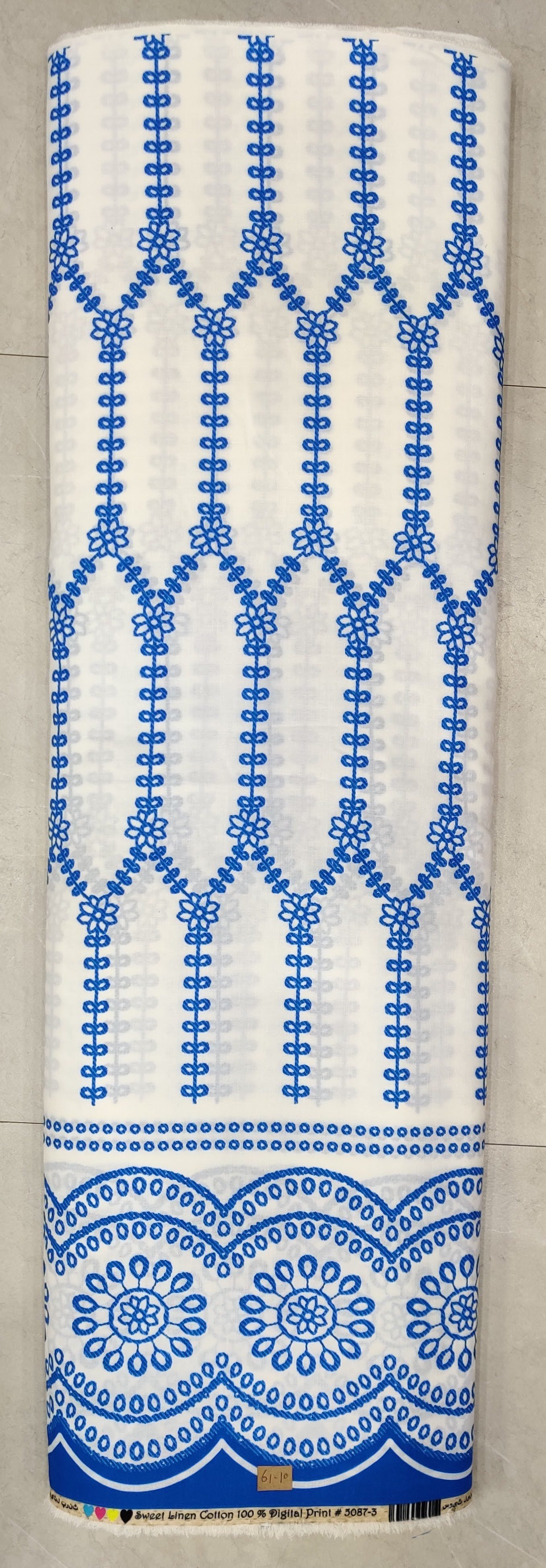 Crisp white and soft-blue fabric featuring a structured architectural block-print motif with repeating symmetrical geometric patterns and a neat vertical border.