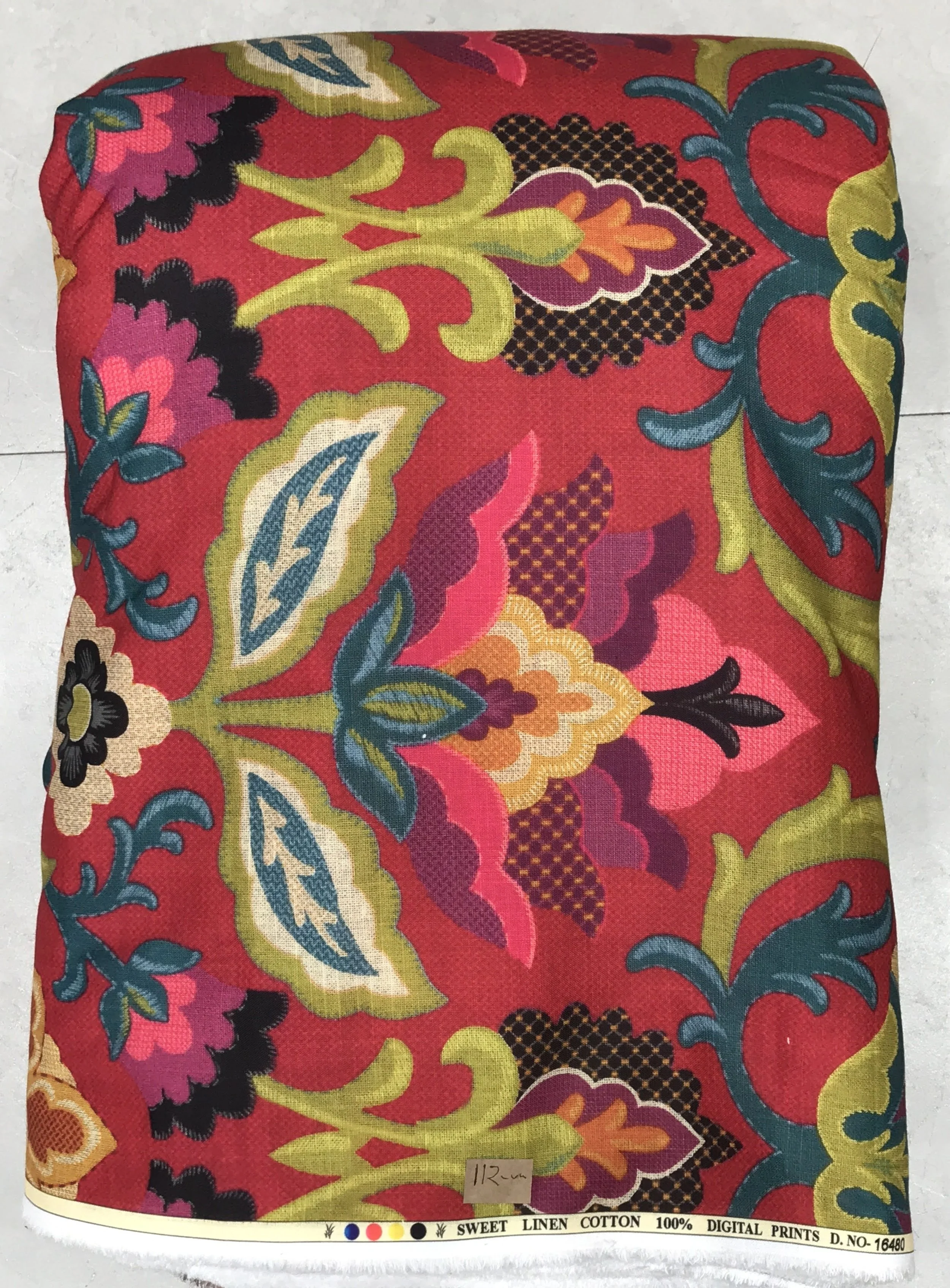 Vibrant magenta-pink, rich emerald-green, and deep black fabric showcasing an ornate all-over Persian-style paisley and floral print featuring symmetrical blooming motifs, curving vines, and intricate traditional detailing.