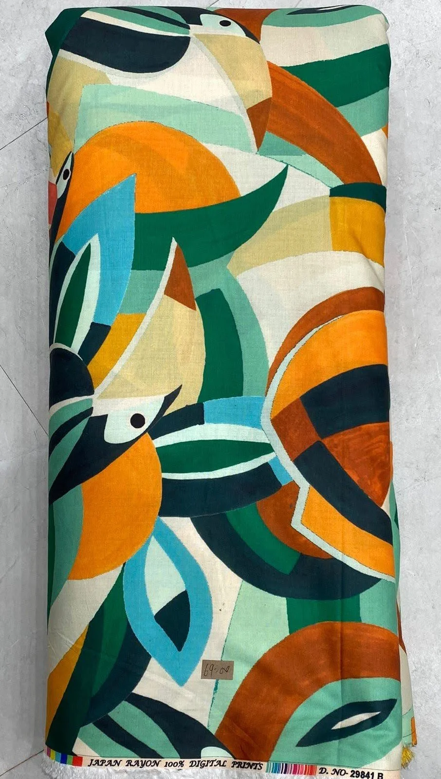 Rich multi-colored fabric featuring an abstract, dynamic composition with flowing brushstrokes and fluid organic shapes in warm orange, deep blue, green, and cream tones against a dark backdrop.