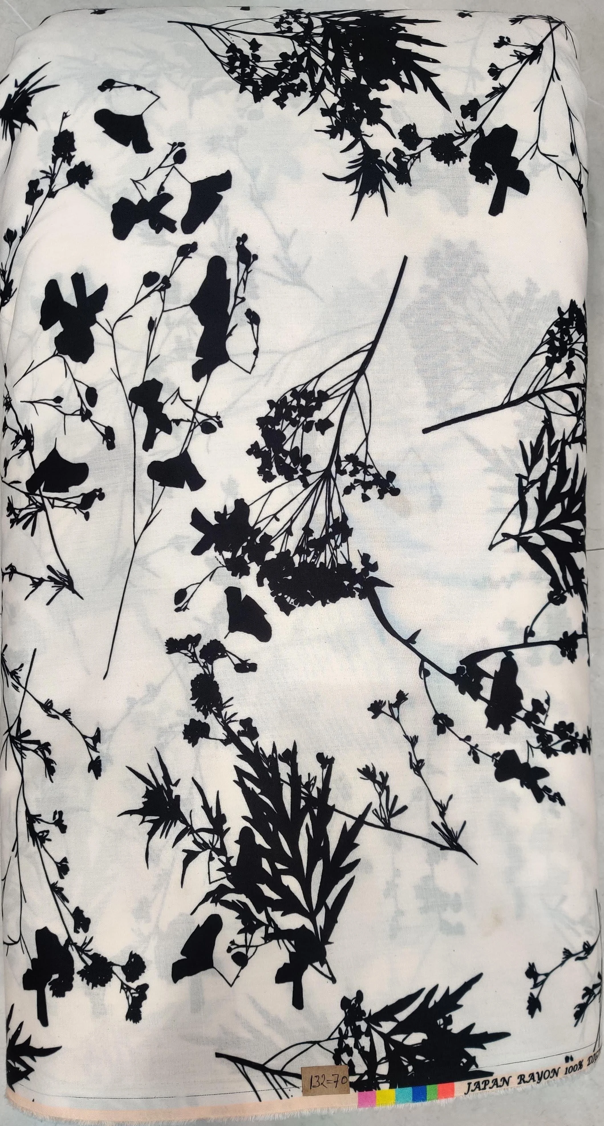Rich white fabric featuring a delicate, sparse botanical branch pattern with subtle black and grey linear motifs.