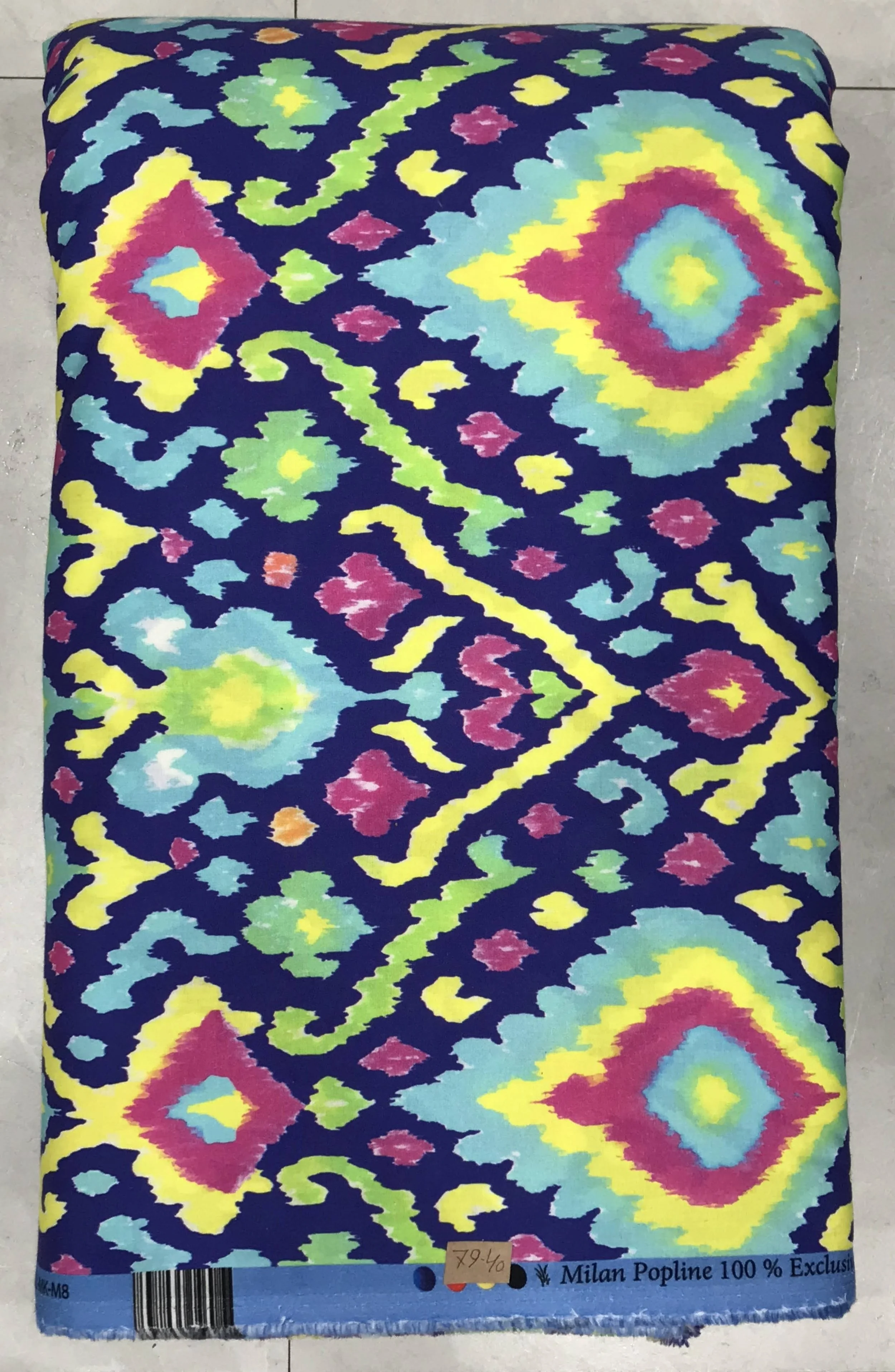 Vibrant royal blue background featuring a dense, colorful bohemian tribal ikat pattern with vivid splashes of yellow, pink, and turquoise geometric motifs.