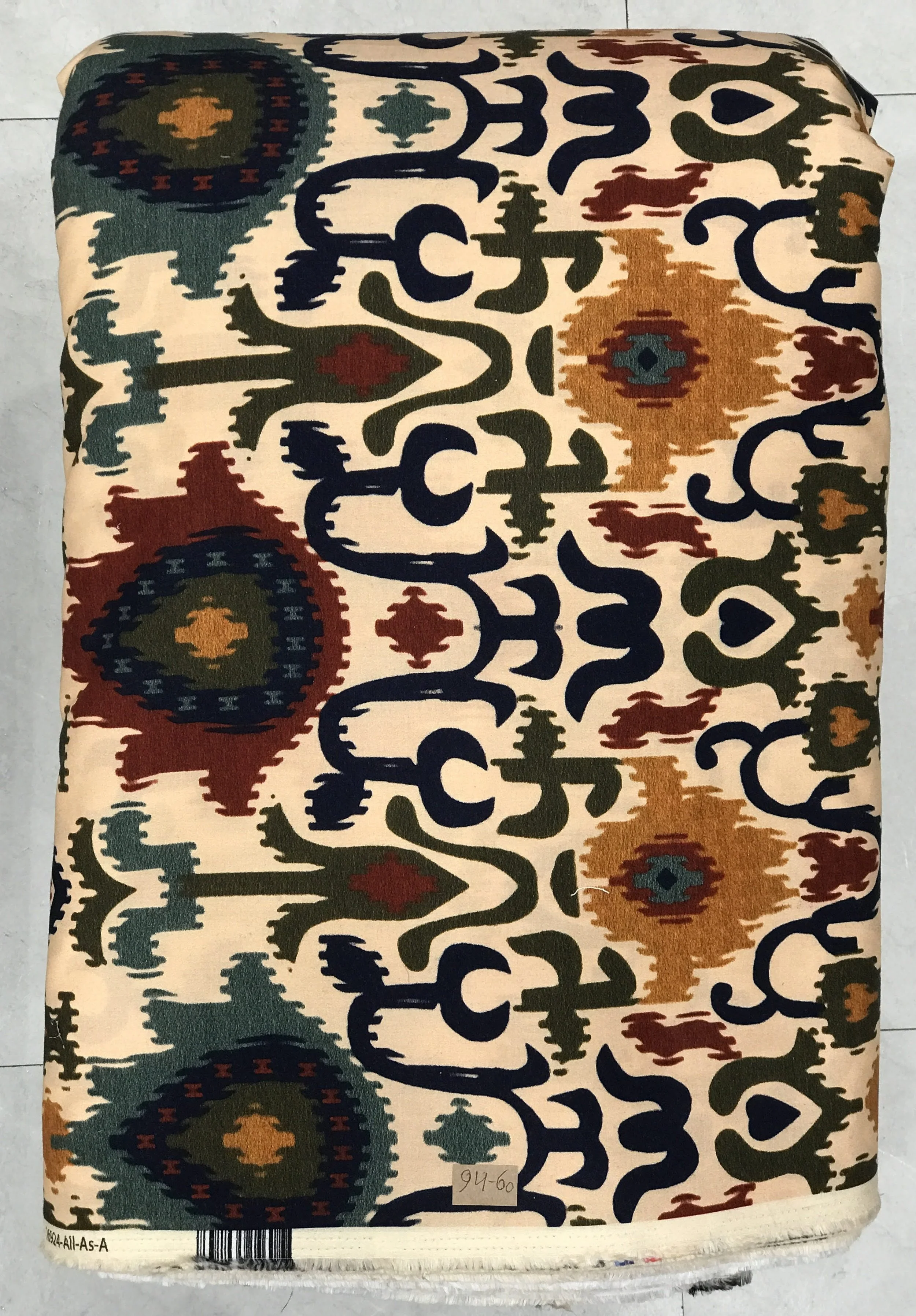 Rich deep green background featuring an intricate traditional ikat-style pattern with ornate medallion motifs and delicate botanical accents.