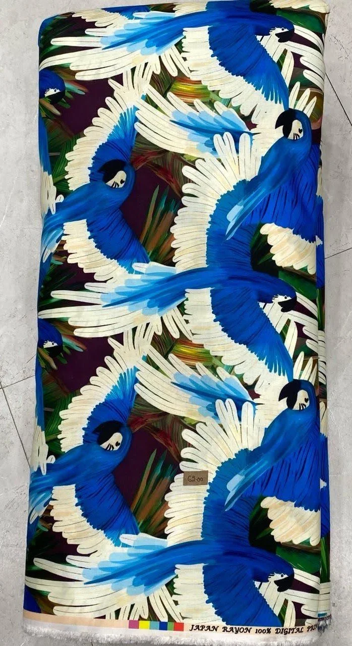 Rich royal-blue fabric featuring a dynamic, sweeping pattern of graceful white birds in flight amidst flowing organic motifs.