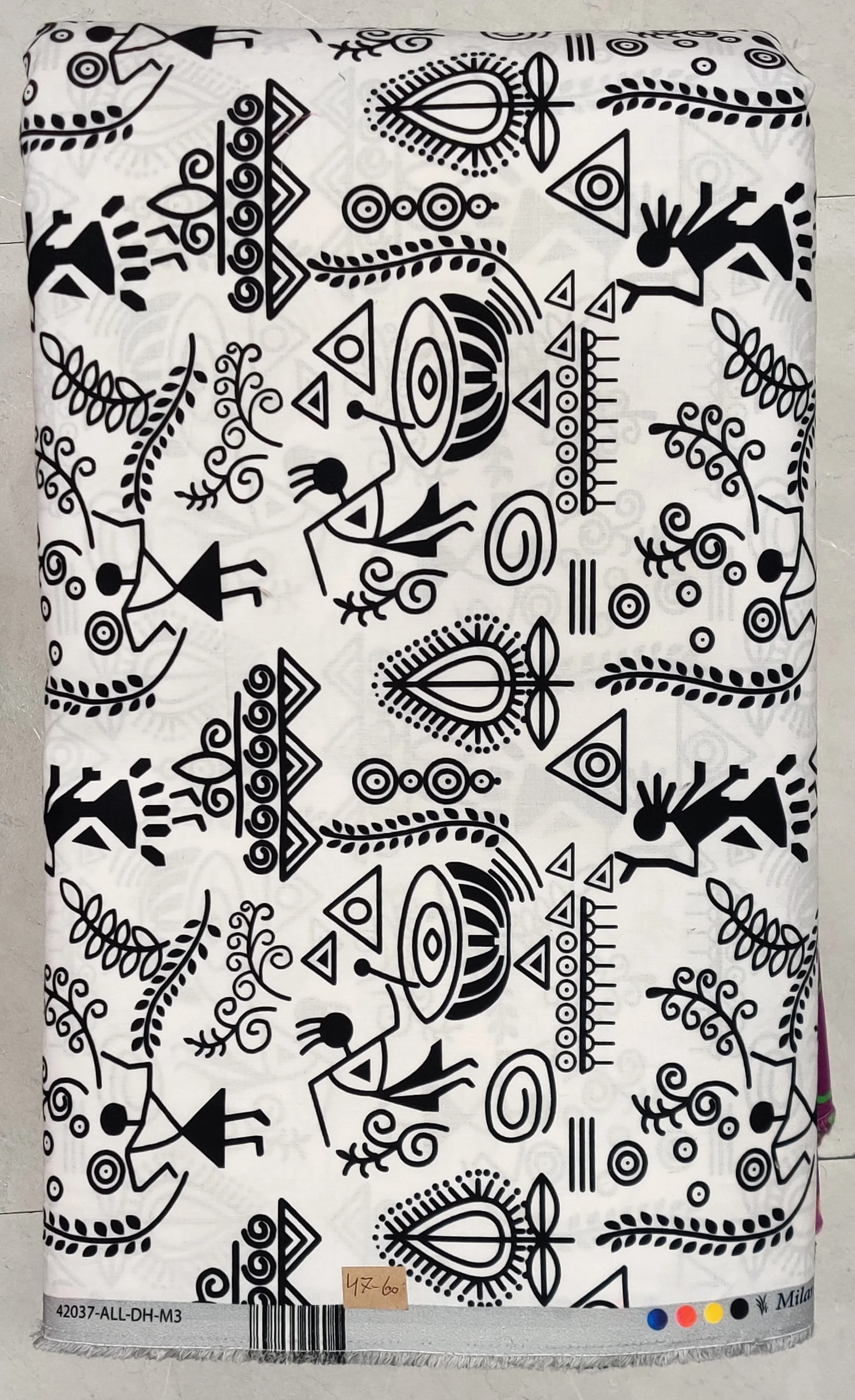 Crisp white background featuring a detailed, folk-art Warli tribal print with traditional geometric human figures, animals, huts, and native cultural motifs in striking black ink.