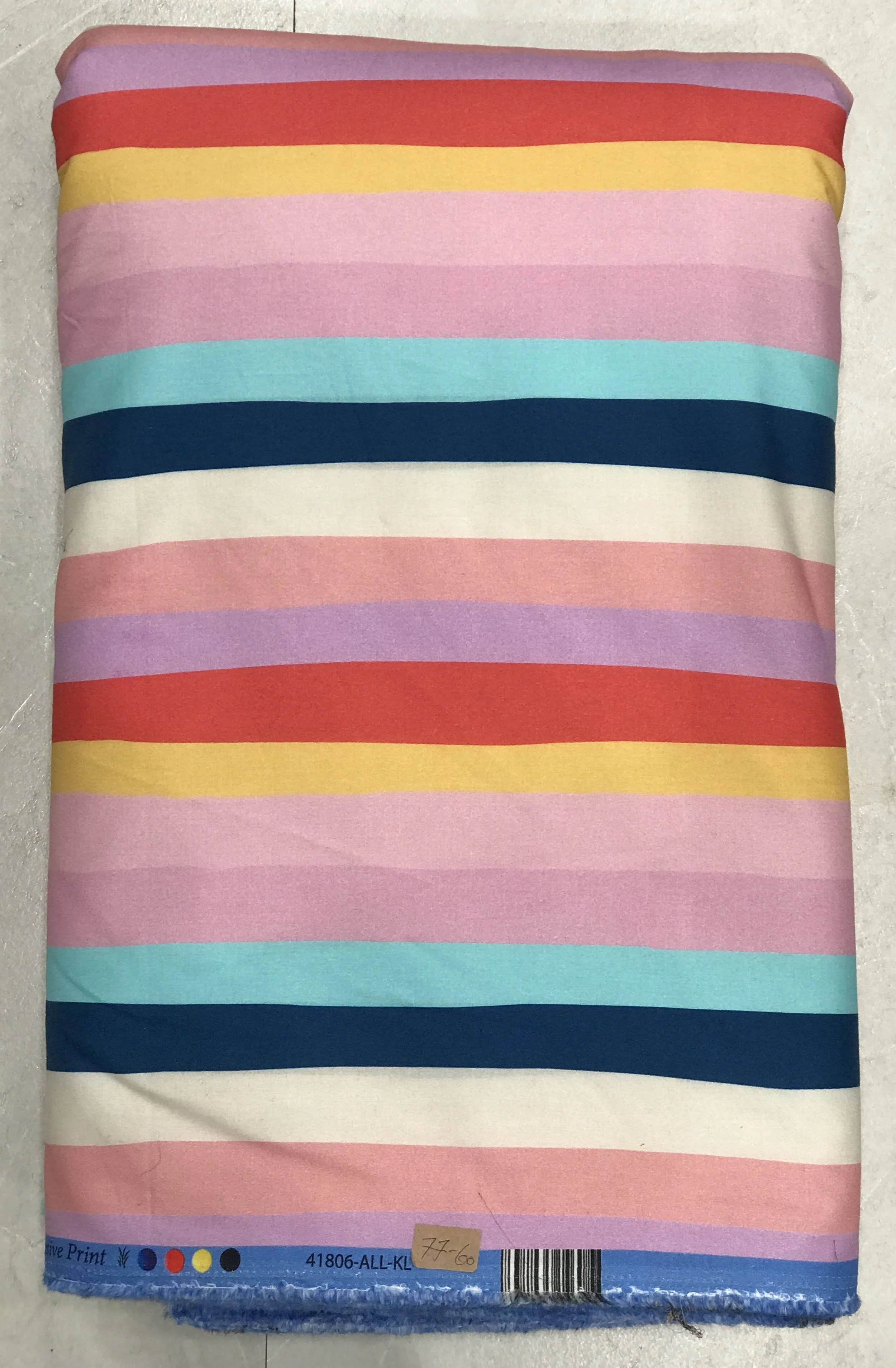 A neat stacked roll of soft-fabric featuring a clean horizontal multi-stripe pattern with alternating bands of white, soft pink, bold navy blue, light blue, and warm yellow tones against a textured neutral background.
