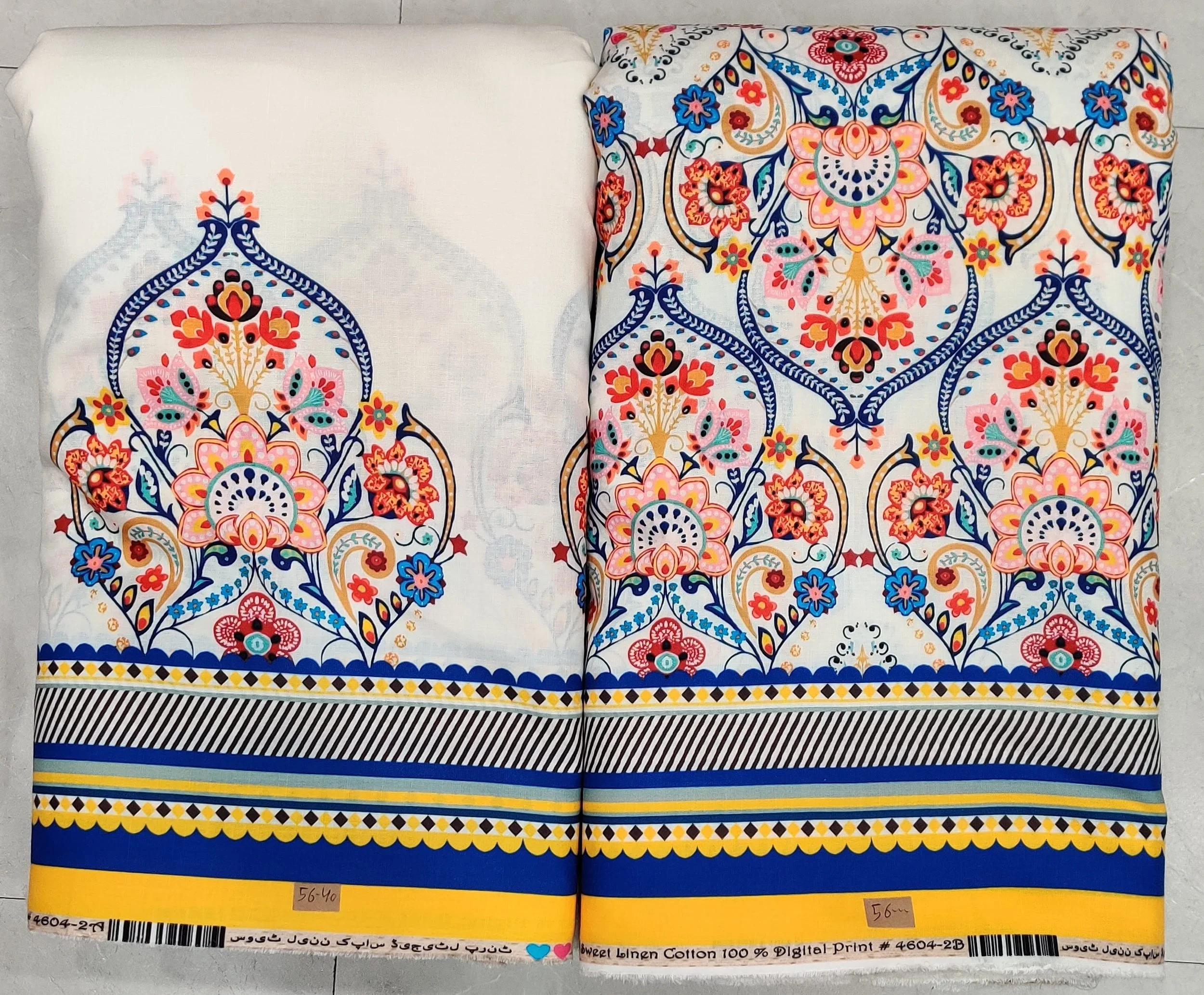 Crisp white and royal-blue fabric featuring an elaborate baroque panel print with symmetrical ornamental motifs on the left, paired with an intricate geometric border and patterned hemline along the right.