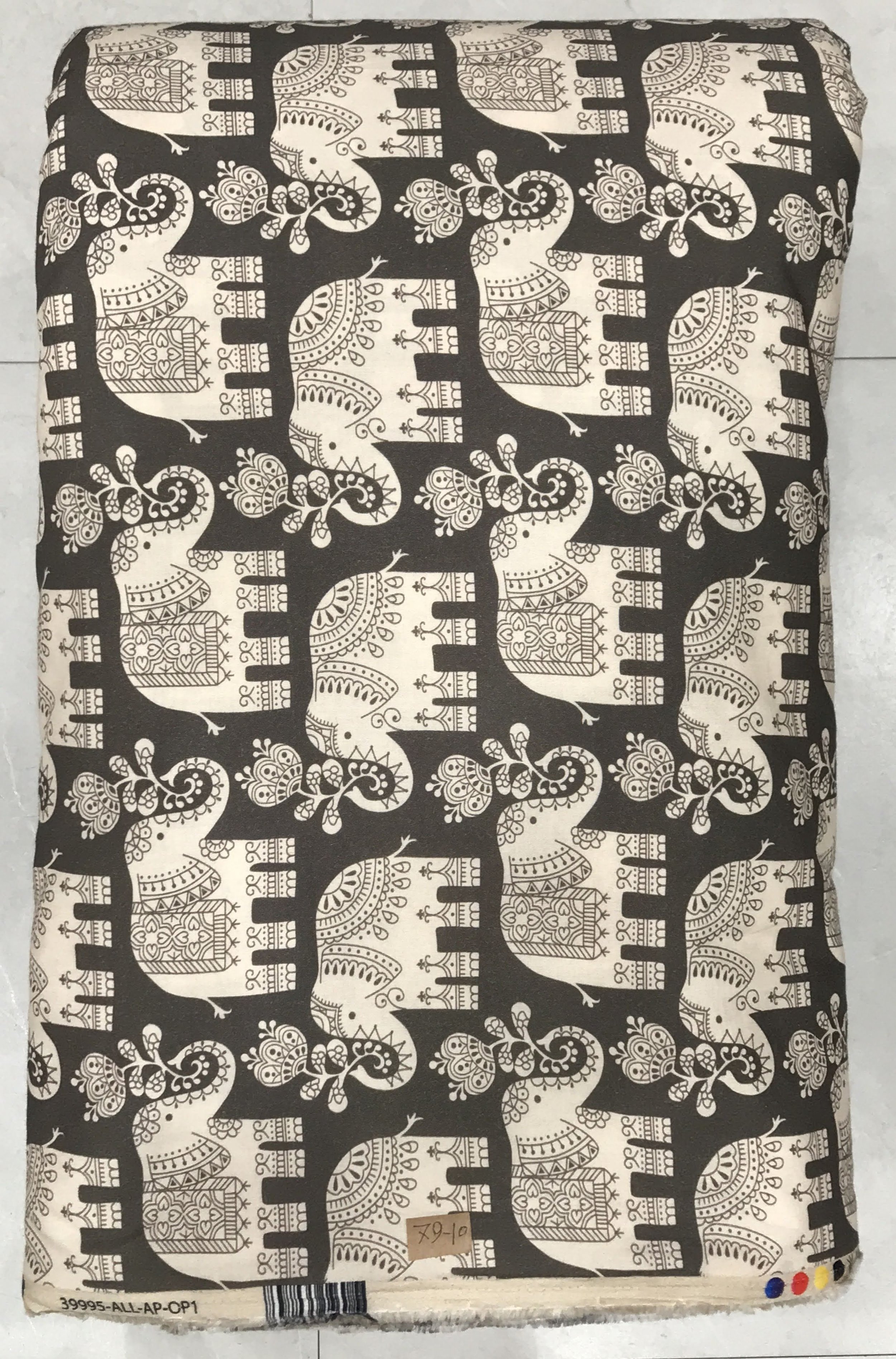 Rich dark charcoal or black background featuring a majestic, traditional print with repeating rows of ornate, caparisoned elephants surrounded by intricate baroque and scrolling floral motifs.